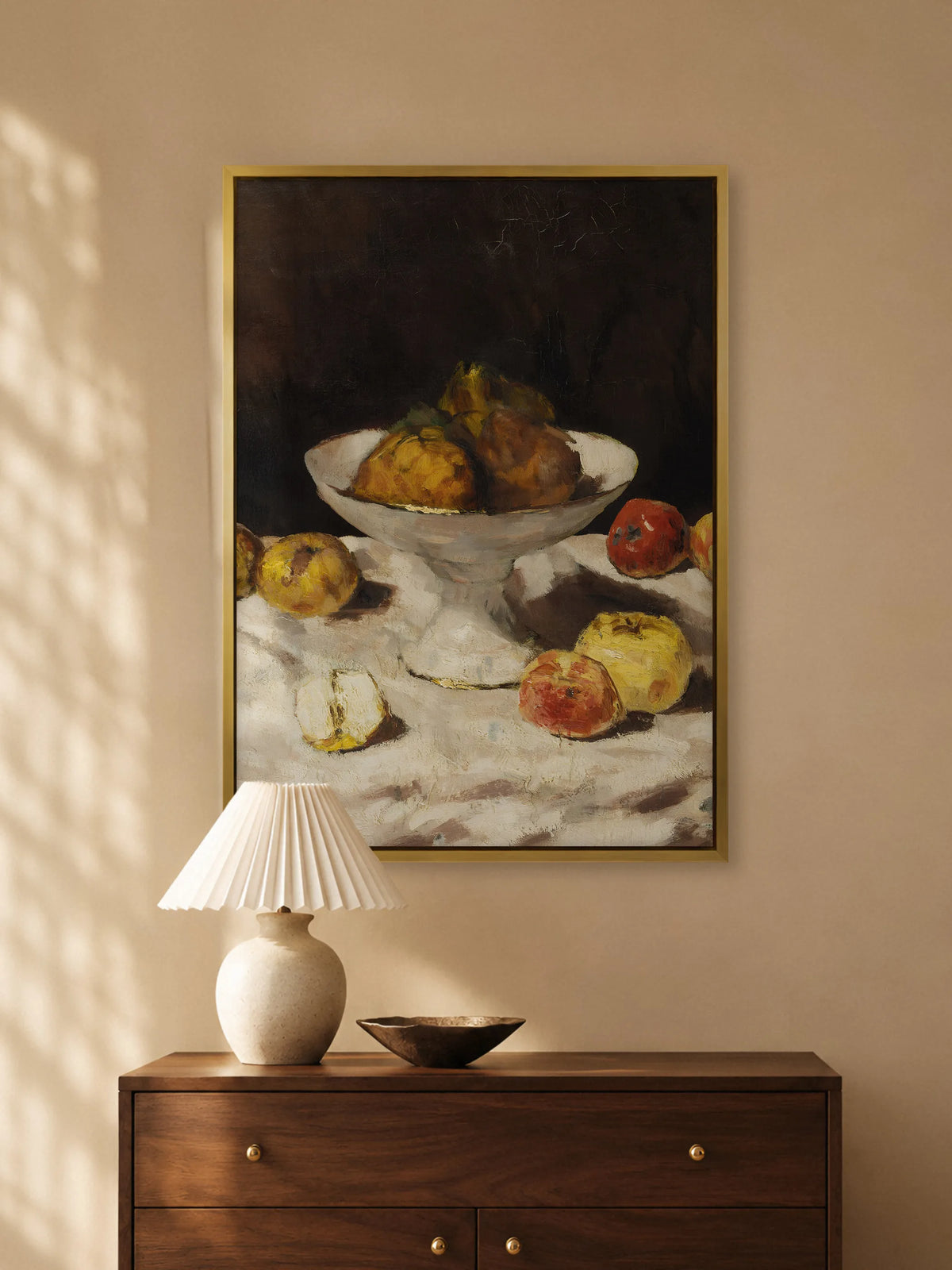 Stillleben mit Äpfeln als Leinwandbild im goldenen Rahmen über einer Kommode aus Nussbaum mit Plisseeleuchte und Schale aus Bronze im Abendlicht