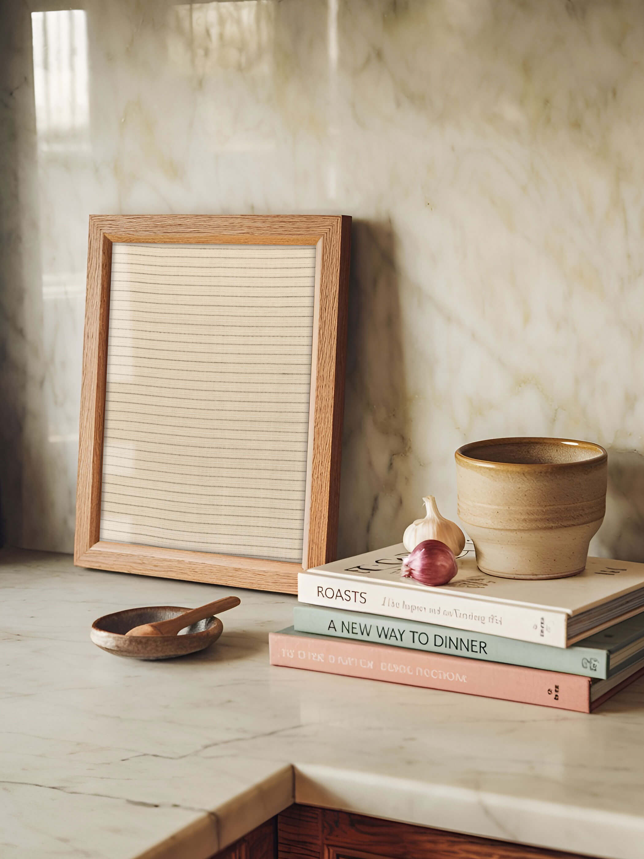 Minimalistisches Wabi-Sabi-Poster mit dezenten Streifen steht auf einer Küchenarbeitsplatte, dekoriert mit Kochbüchern, einer Knoblauchzehe und einem Holzlöffel.
