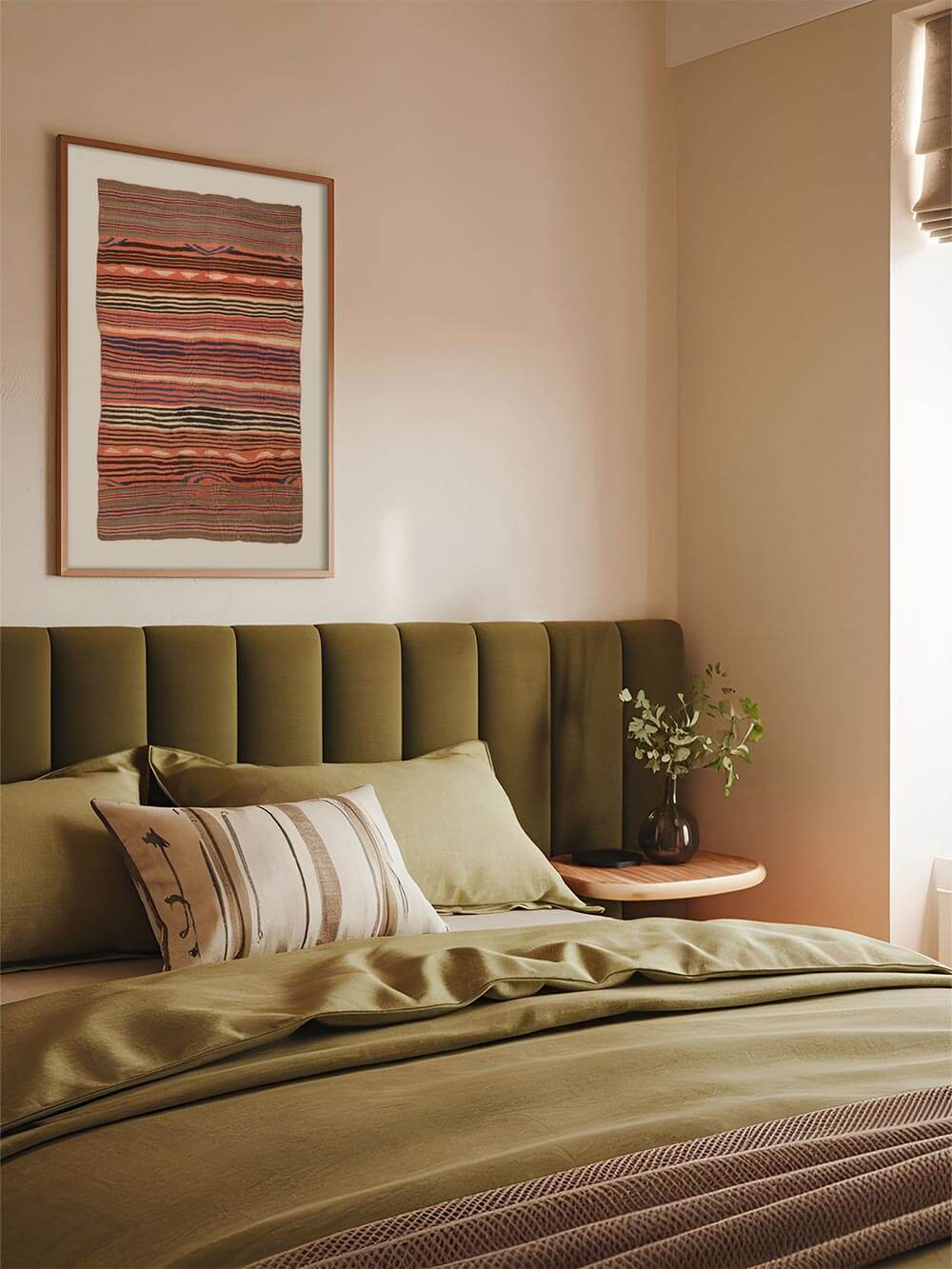 Der textile Kunstdruck hängt gerahmt über einem Bett mit grüner Tagesdecke und schafft eine warme, entspannte Atmosphäre. Die erdigen Farben des Wandbilds ergänzen den ruhigen Einrichtungsstil und passen ideal zu Wabi-Sabi- oder Boho-Schlafzimmern.