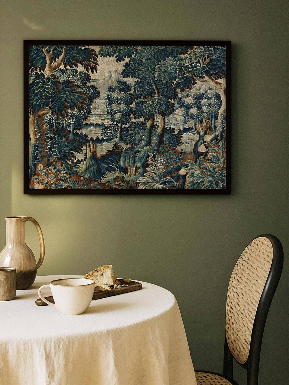 Verdure-Wandbild mit klassischer Landschaftsdarstellung hängt gerahmt über einem runden Esstisch in einem gedeckten Esszimmer und verbindet natürliche Farben mit zeitloser Eleganz für eine stilvolle, ruhige Raumwirkung.