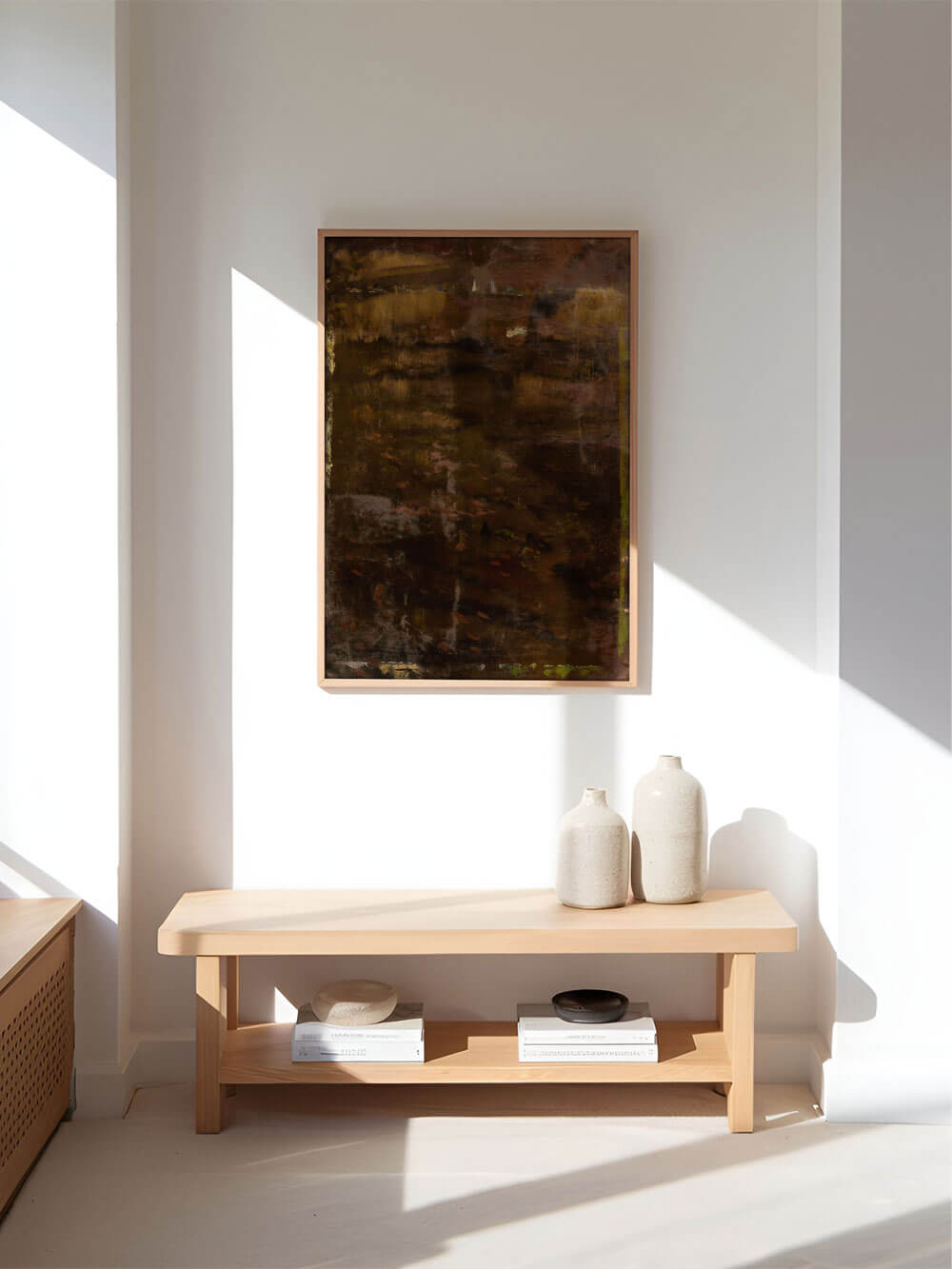 Dunkles abstraktes Kunstposter in natürlichem Licht, gerahmt an einer weißen Wand. Das Kunstwerk zeigt tiefbraune und goldene Akzente, die eine warme und stimmungsvolle Atmosphäre erzeugen. Moderne Dekoration mit Keramikvasen auf einem Holzregal darunter.