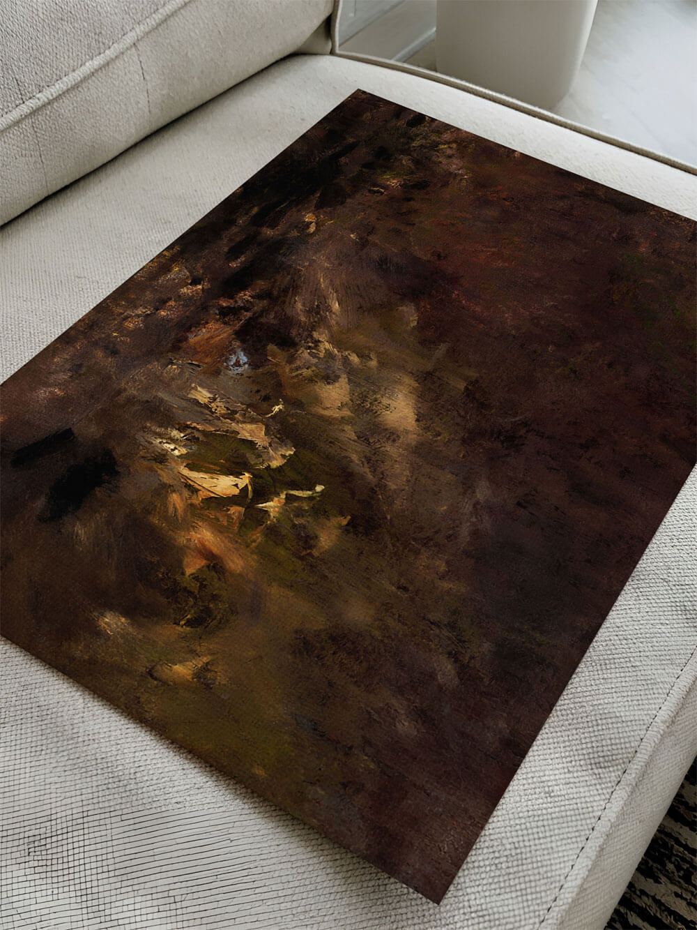 Dunkler abstrakter Kunstdruck in Erdtönen, auf einem Sofa liegend, mit subtilen Farbschattierungen in Braun, Grün und Gold.