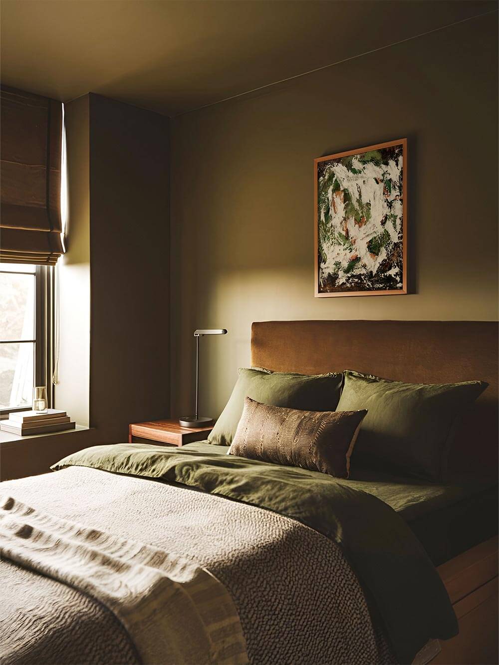 Abstrakter Kunstdruck in Grün und Creme hängt über einem Bett mit olivfarbener Bettwäsche in einem ruhig gestalteten Schlafzimmer. Das Wandbild mit strukturierter Oberfläche wirkt erdend und ruhig und passt zu Wabi Sabi Einrichtung, natürlicher Raumgestaltung und moderner Wandkunst.