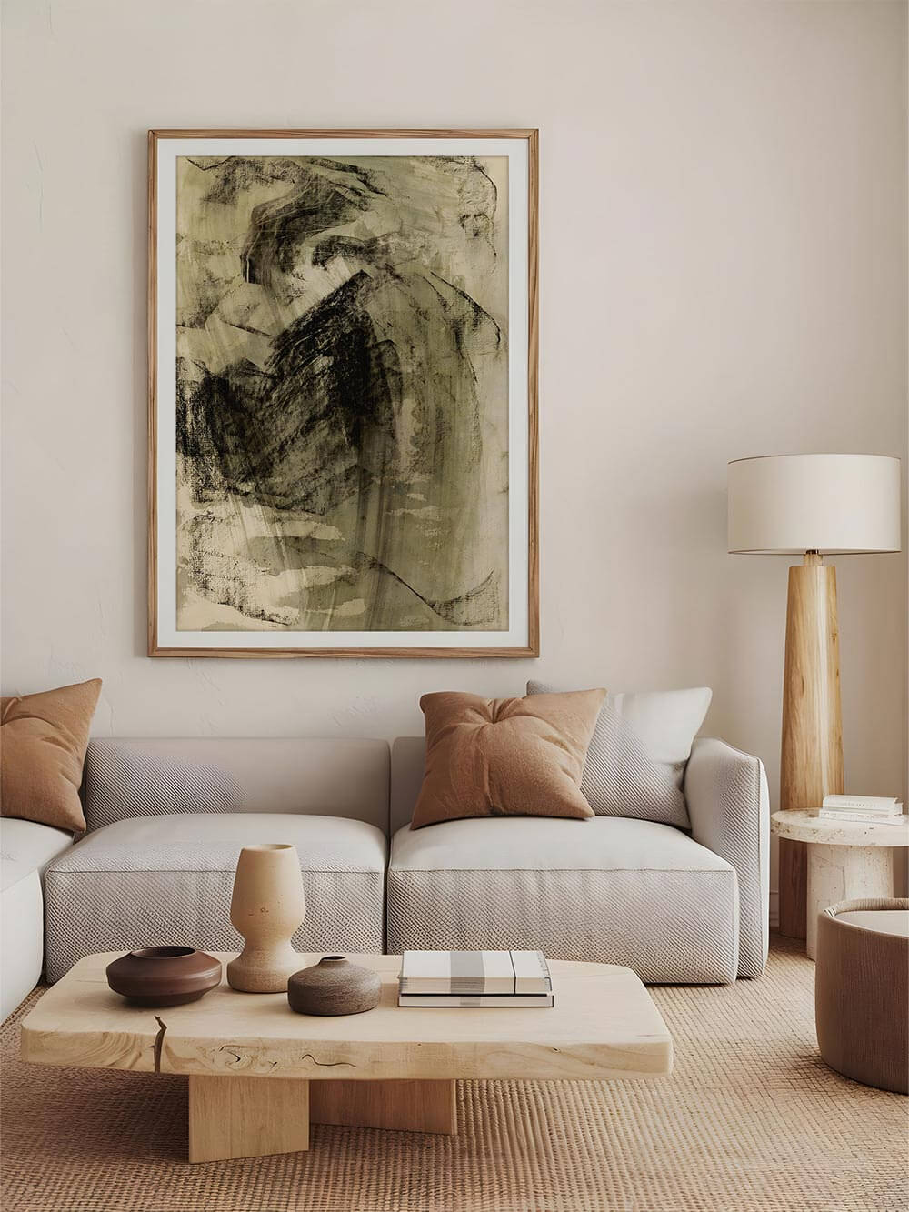 Der große Wabi-Sabi Kunstdruck hängt gerahmt über einem cremefarbenen Sofa mit Naturdeko. Die gedeckten Farbtöne des Wandbilds ergänzen das sanfte Interior harmonisch.