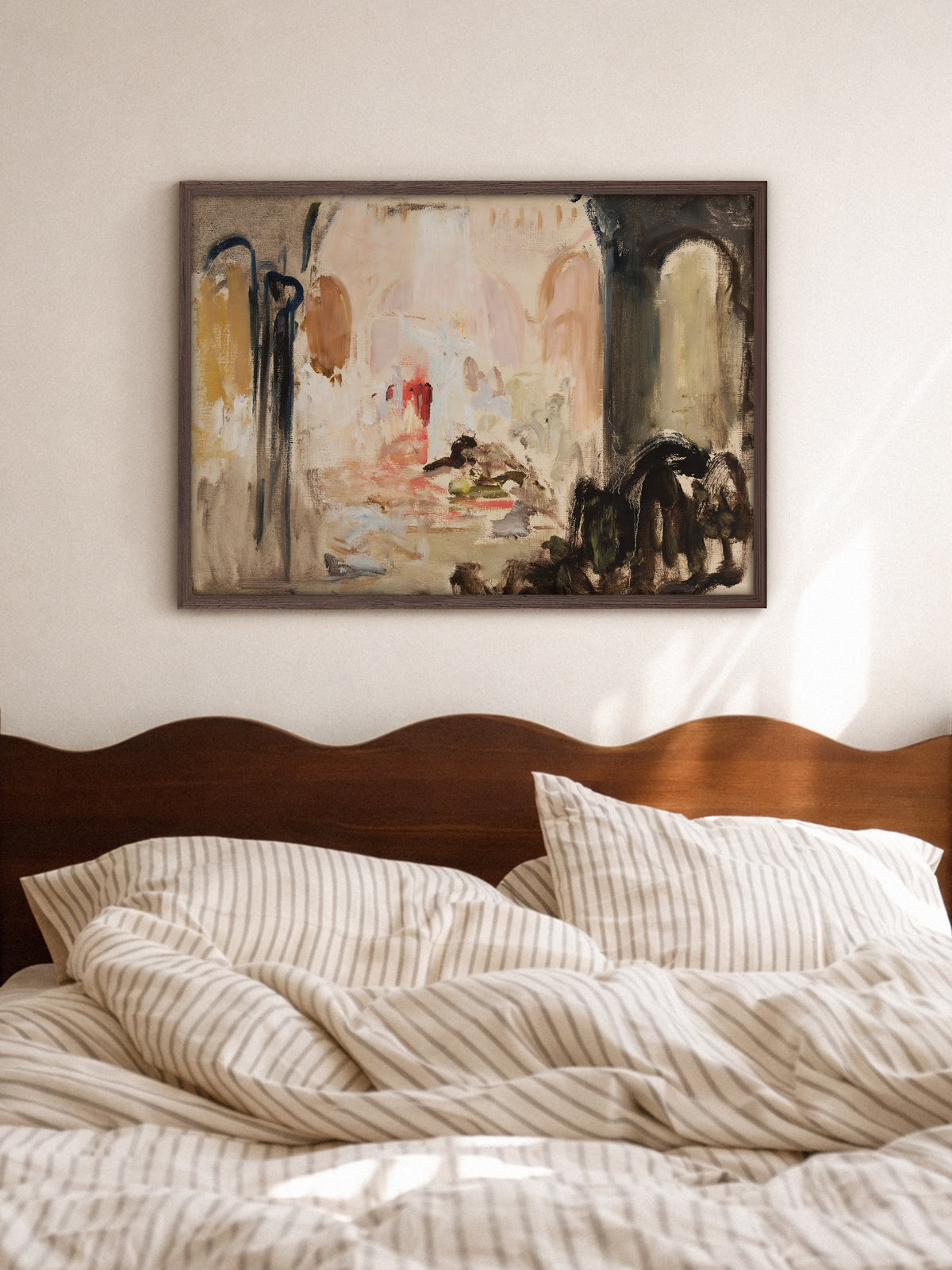 Abstraktes Poster in Erdtönen im Rahmen aus dunklem Holz über einem Bett mit gewelltem Kopfteil aus Holz und gestreifter Bettwäsche. Das Wandbild im Wabi-Sabi-Stil fügt sich ruhig in das helle Schlafzimmer ein.