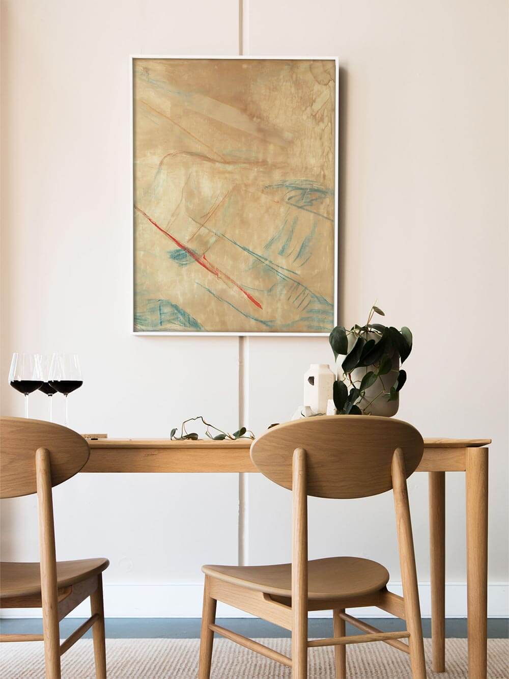 Großformatiges abstraktes Wandbild mit sanften Beige-, Blau- und Akzentlinien in Rot ist über einem Holztisch im Esszimmer platziert. Der Kunstdruck ergänzt die klare Formsprache und passt ideal zu Japandi- und minimalistischer Raumgestaltung.