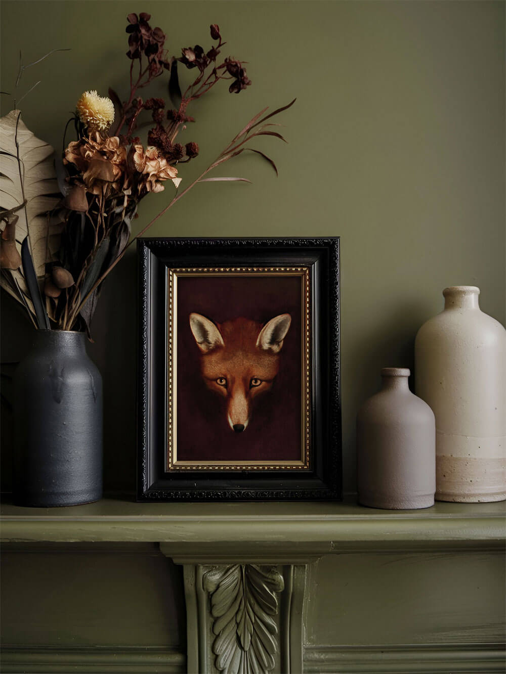 Ein kleiner Fuchs-Kunstdruck in einem eleganten, schwarzen Rahmen, auf einem grünen Regal arrangiert mit getrockneten Blumen und Vasen. Die warmen, erdigen Töne des Drucks harmonieren perfekt mit der stilvollen Dekoration.