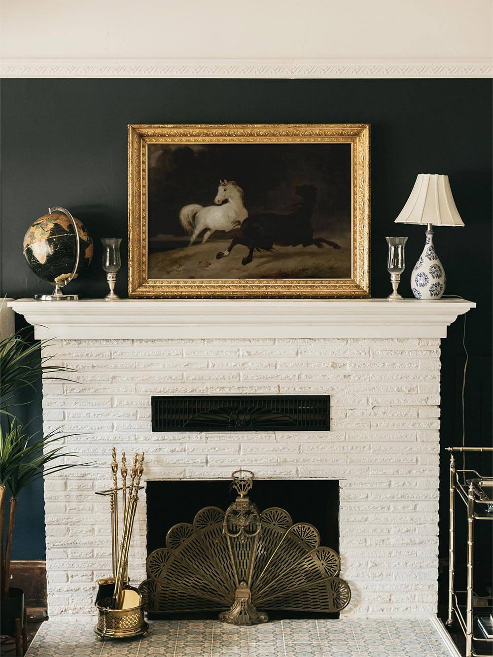 Großformatiges Pferde-Wandbild über einem weißen Kamin vor dunkelgrüner Wand. Der antike Stil, der goldene Rahmen und die dynamische Bewegung der Pferde verleihen dem Raum Tiefe und eignen sich ideal für klassische Wohnzimmer oder Bibliotheken.