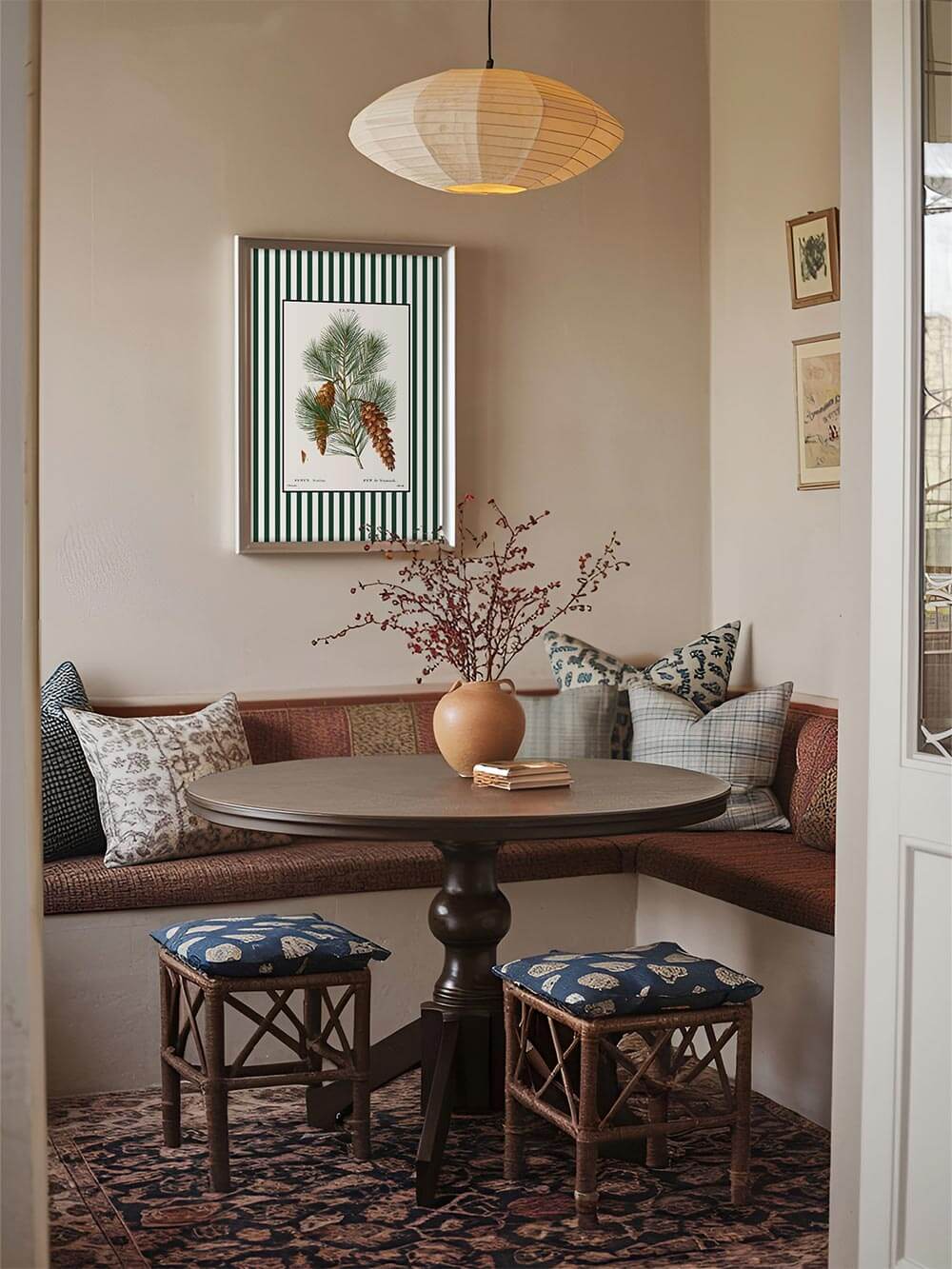 Botanisches Wandbild Pin de Weymouth mit grün-weiß gestreiftem Rand über einem runden Tisch in gemütlicher Sitzecke, warmes Licht, Vintage-Dekor mit natürlicher Note.