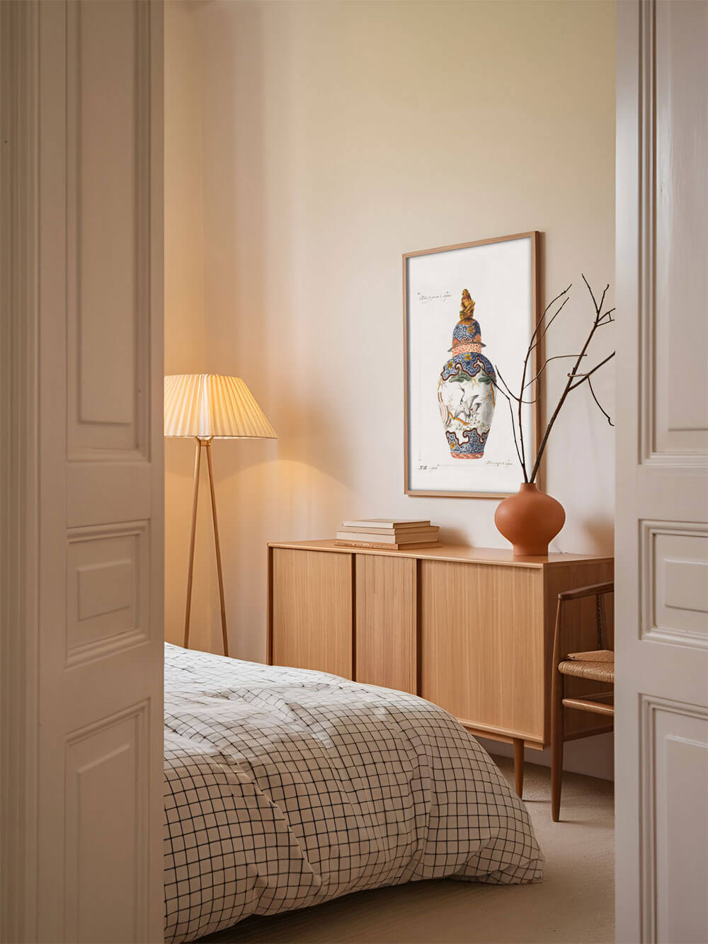 Schlafzimmer mit sanften, warmen Tönen, dekoriert mit einem Vintage-Kunstdruck einer antiken Chinoiserie-Vase, elegant in einem Holzrahmen an der Wand aufgehängt.