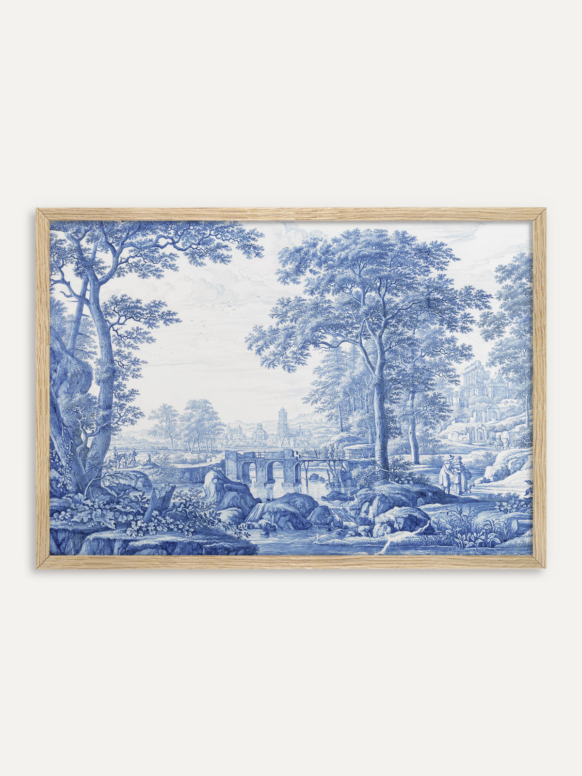 Kunstdruck, der eine Flusslandschaft in Kobaltblau auf Weiß zeigt, mit hohen Bäumen, einer Steinbrücke über einen Bach, Felsen, Spaziergängern und einer fernen Stadt mit Turm. Im Rahmen aus hellem Holz wirkt das blau-weiße Motiv frisch und passt zu einer Einrichtung im Landhausstil. #Rahmen_Helles Holz