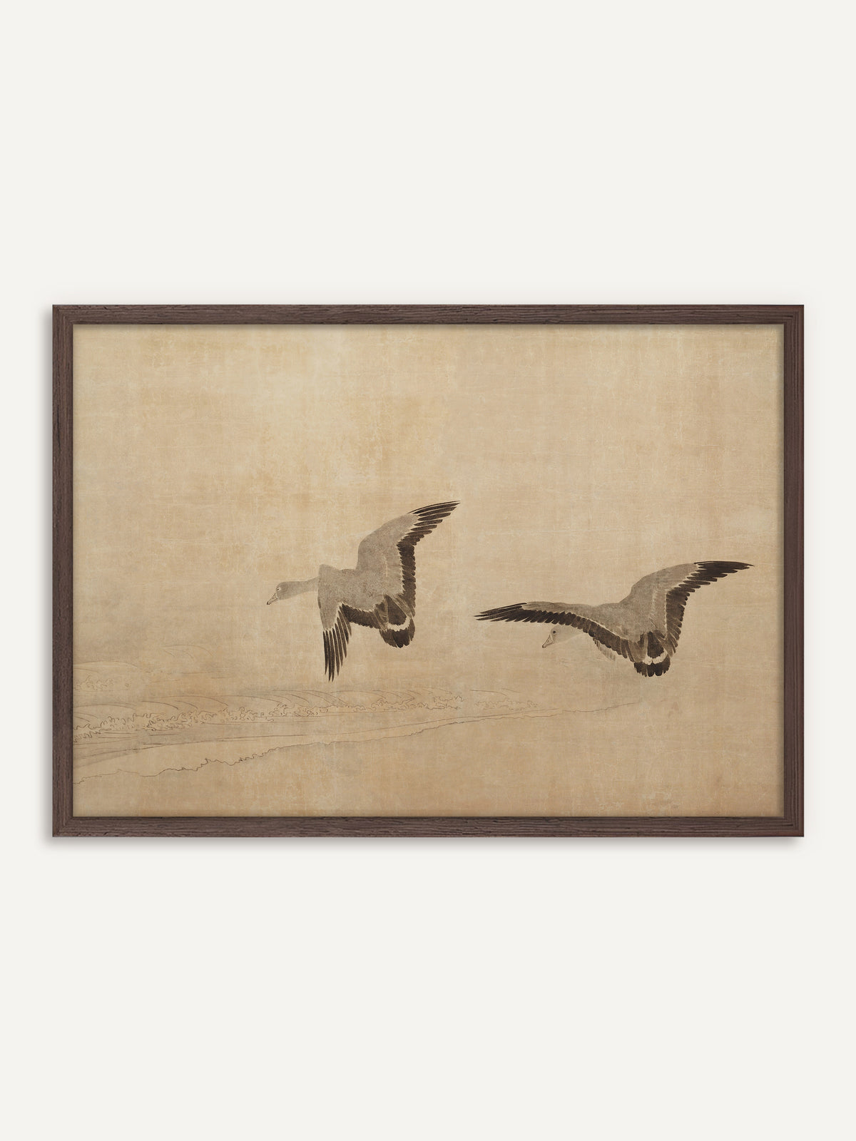 Poster, das zwei Gänse mit ausgebreiteten Schwingen in Grau und Braunschwarz zeigt, die über feine Wellenlinien an einem Strand fliegen, auf warmem, sandfarbenem Grund. Der Rahmen aus dunklem Holz nimmt das dunkle Gefieder auf und betont die Wabi-Sabi-Ruhe des Bildes. #Rahmen_Dunkles Holz