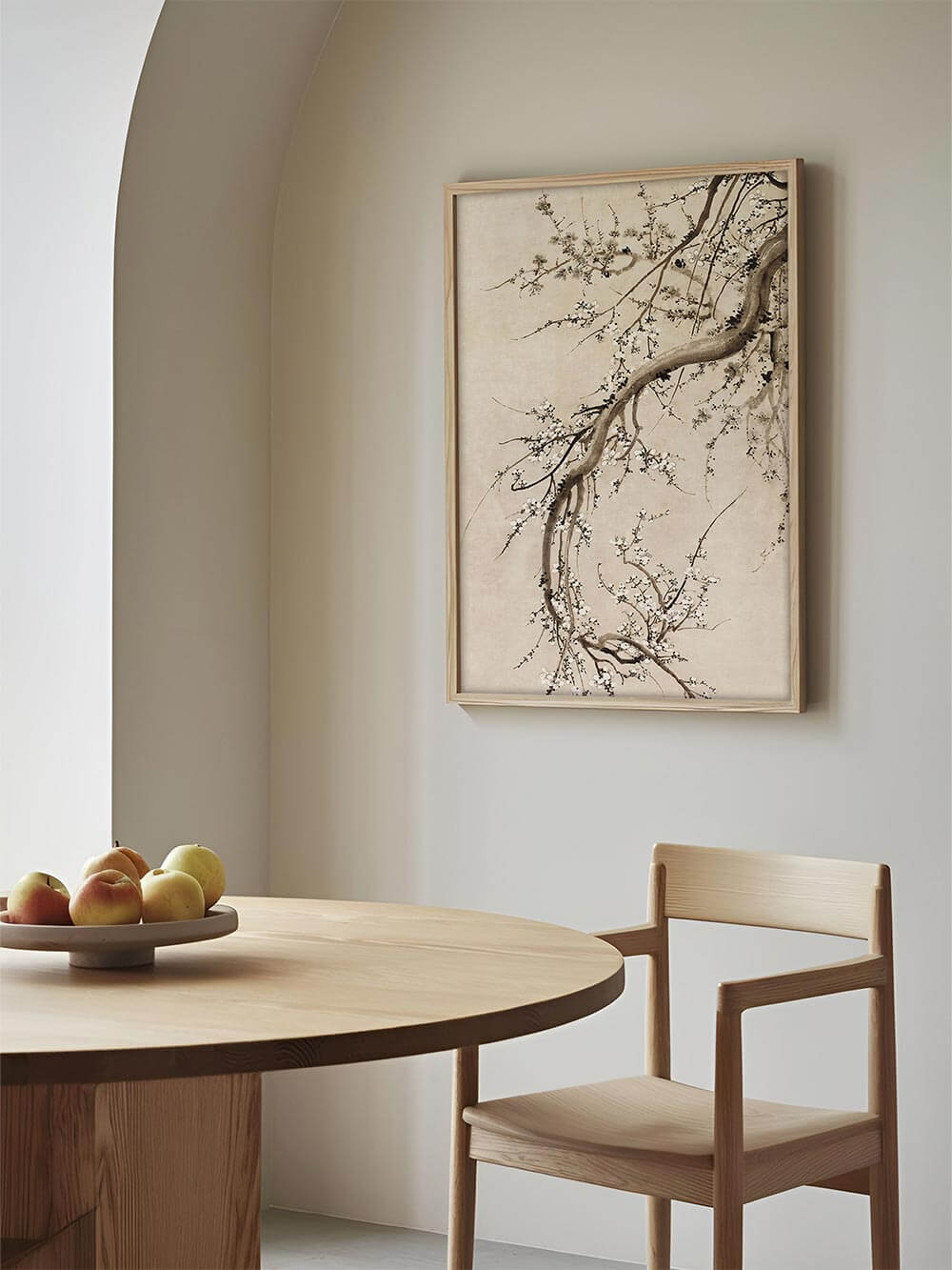 Der gerahmte Kirschblüten Kunstdruck hängt über einem runden Holztisch. Die helle Illustration bringt Leichtigkeit und eine fernöstlich inspirierte Ruhe in den Raum.
