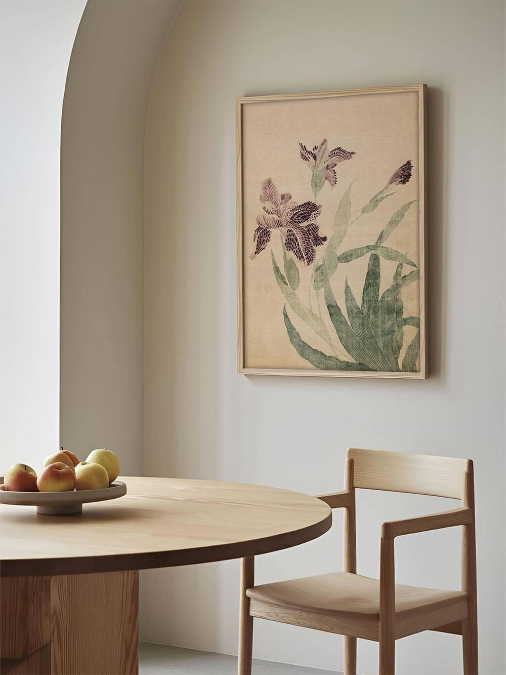 Gerahmter Kunstdruck mit violetten Irisblüten hängt über einem runden Holztisch im Esszimmer. Die botanische Illustration schafft eine ruhige, elegante Atmosphäre.