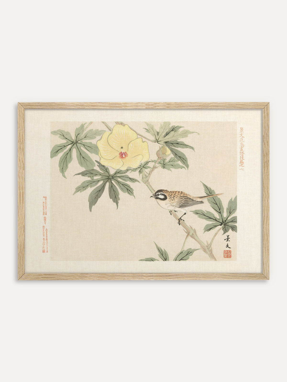 Kunstdruck, der einen braun gesprenkelten Vogel mit schwarz-weißem Gesicht auf einem Stängel zeigt, darüber eine große hellgelbe Hibiskusblüte mit rotem Zentrum zwischen grünen Blättern, vor cremefarbenem Grund mit Schriftzeichen und rotem Siegel. Im Rahmen aus hellem Holz wirkt das sonnige Motiv frisch und passt zu einer Einrichtung im Japandi-Stil. #Rahmen_Helles Holz