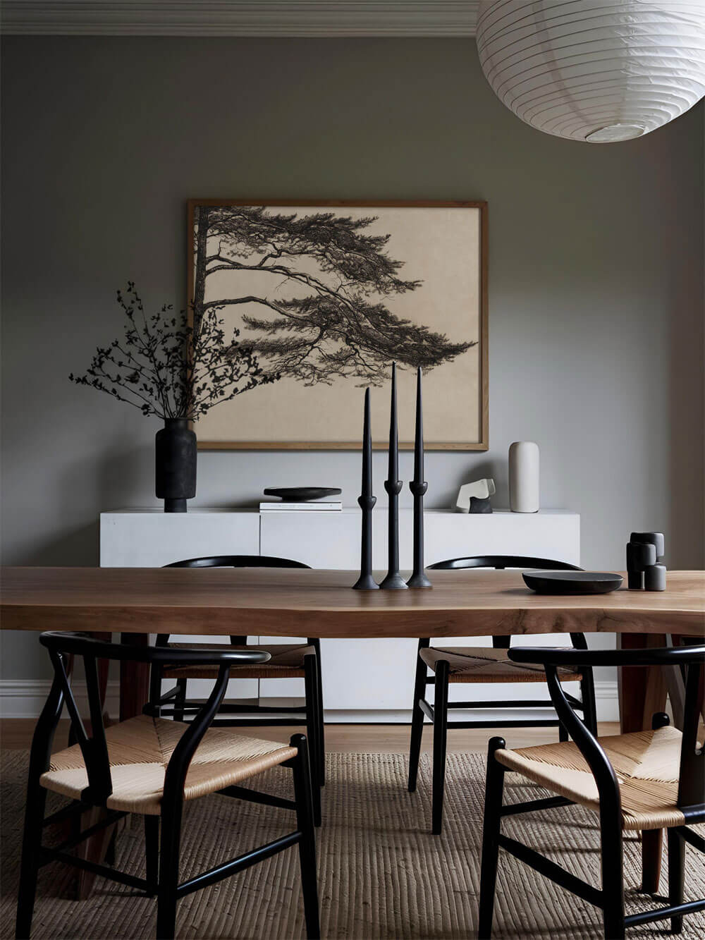 Minimalistisches Esszimmer mit einem Vintage-Pinienbaum-Poster, elegant eingerahmt an der Wand hinter einem schlichten Holztisch. Die dunklen Stühle und Kerzenständer harmonieren mit der feinen Linienführung der Baumzeichnung, die Ruhe und Gelassenheit ausstrahlt.