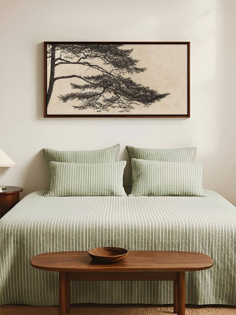 Panorama-Kiefer-Kunstdruck über einem Bett mit grün gestreifter Bettwäsche in einem hellen, minimalistischen Raum. Harmonische Wabi-Sabi-Inneneinrichtung mit ruhiger, natürlicher Atmosphäre.