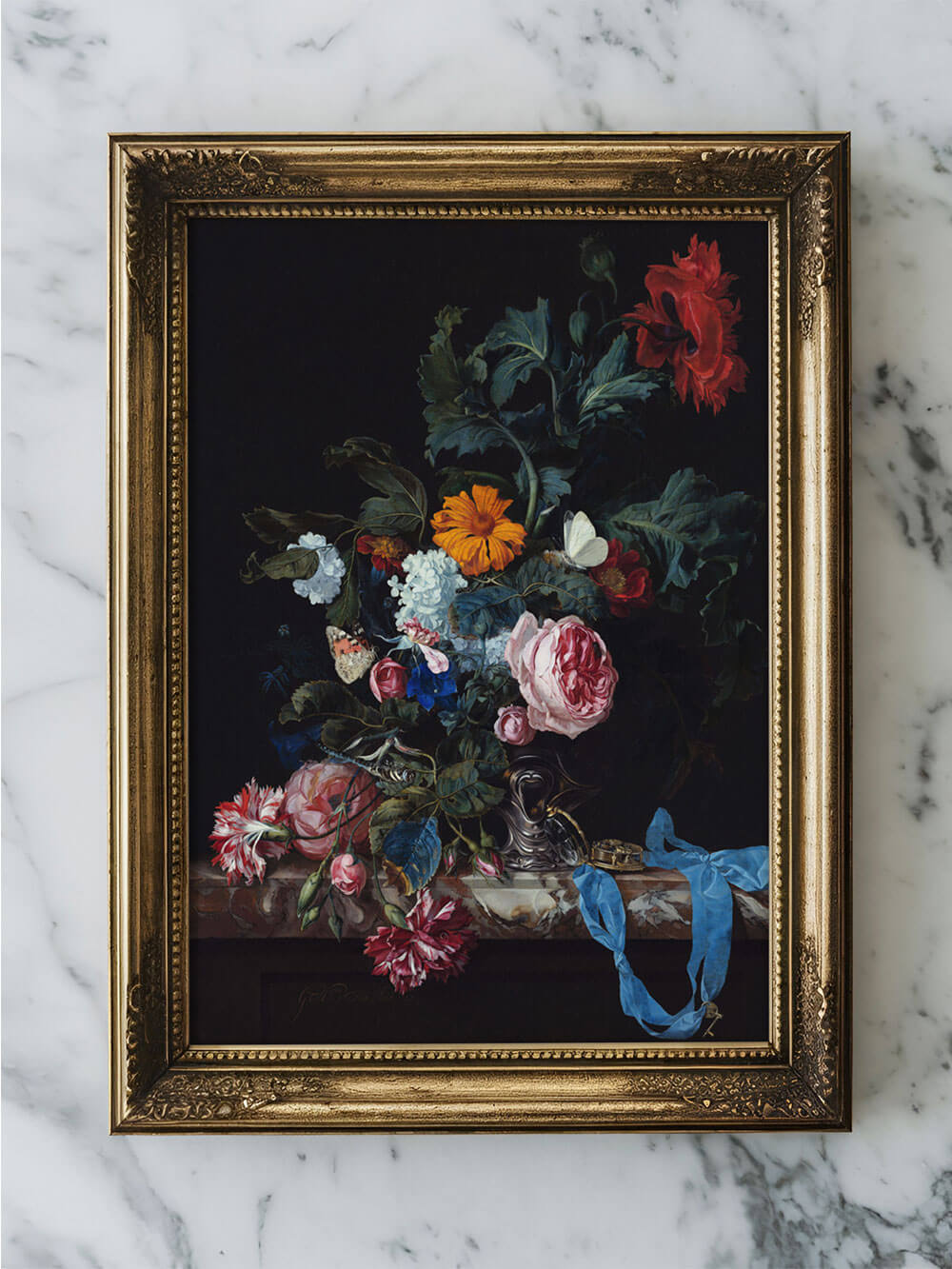 Barocke Blumenstillleben-Kunstdruck ist in einem antik aussehenden, goldverzierten Rahmen gefasst und steht auf einer eleganten Marmorplatte. Auf dem Bild befinden sich realistische Blumen, darunter leuchtend rote, rosafarbene und weiße Blüten, die dramatisch vor dem dunklen Hintergrund hervorstechen.