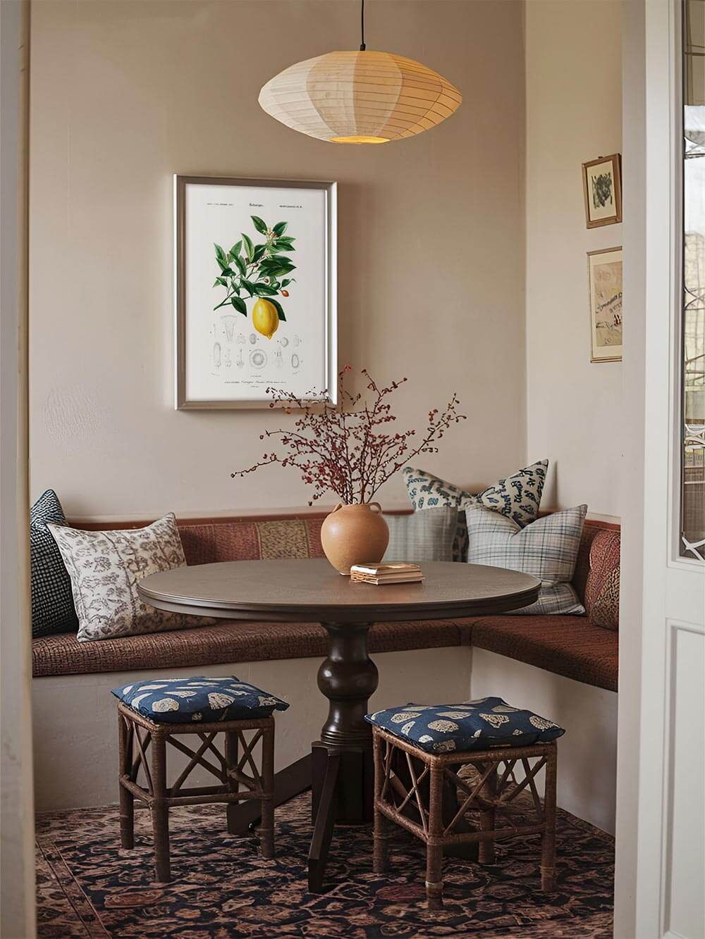 Botanisches Zitronen-Wandbild im Esszimmer mit gemütlicher Bank und rustikalem Holztisch. Perfekte Vintage-Wanddeko für Landhausstil und natürliche Wohnräume.