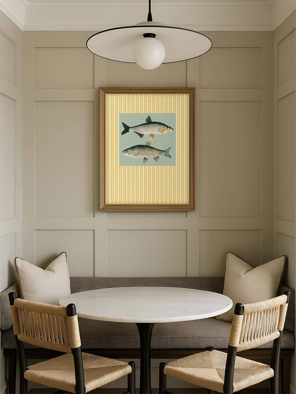 Gerahmter Fisch-Kunstdruck mit Retro-Streifen über einer gemütlichen Essnische mit hellem Rundtisch. Die Illustration setzt einen ruhigen Vintage-Akzent.