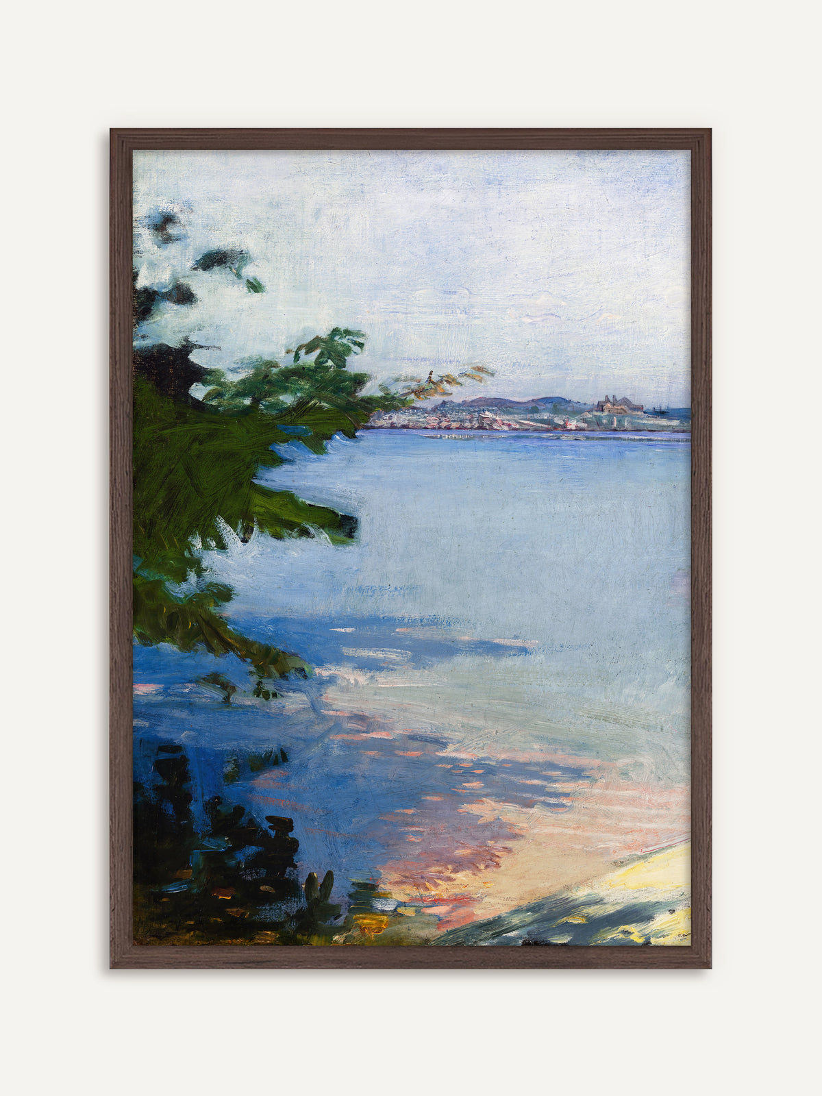 Poster, das eine weite, hellblaue Bucht mit dunkelgrünen Zweigen am linken Rand, einer fernen Stadt am Horizont und rosa und gelben Lichtreflexen am Ufer zeigt. Der Rahmen aus dunklem Holz betont die grünen Zweige und gibt dem hellen Blau Halt. #Rahmen_Dunkles Holz