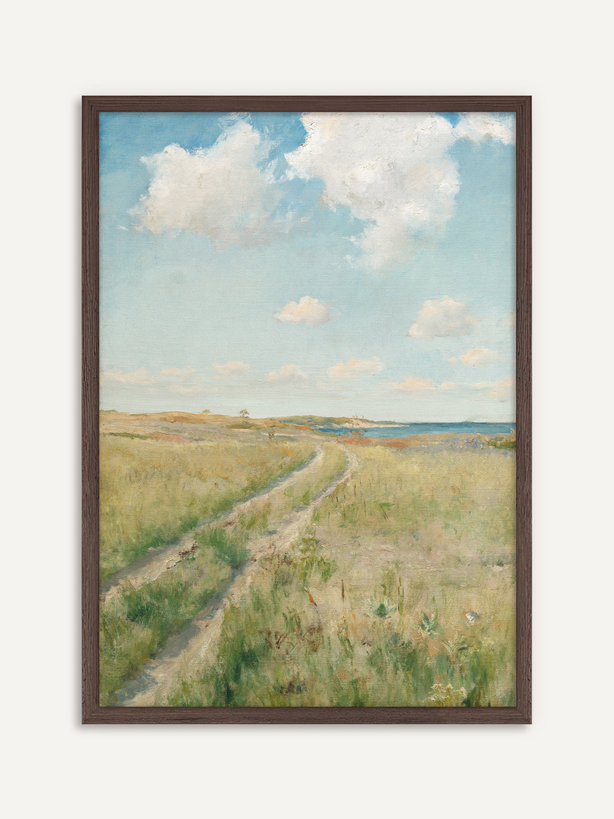 Poster, das einen sandigen Feldweg zeigt, der sich durch eine grüne Sommerwiese zum blauen Meer zieht, darüber große weiße Wolken an einem hellen Himmel. Im dunklen Holzrahmen wirkt die Küstenlandschaft warm und antik. #Rahmen_Dunkles Holz