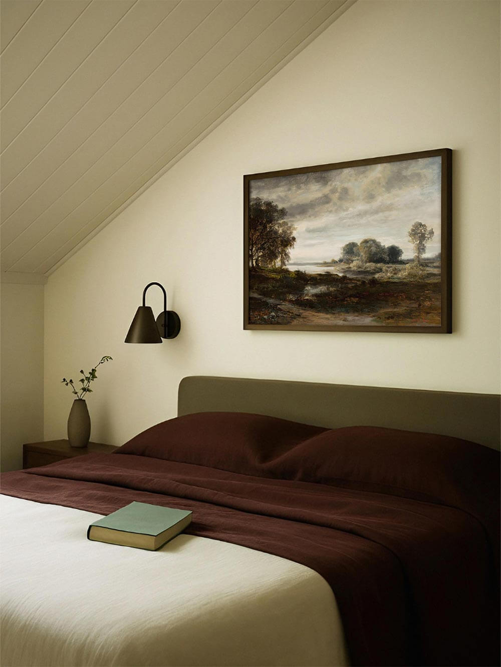 Landschaftskunstdruck über dem Bett in einem ruhigen Schlafzimmer mit warmen Textilien und sanfter Beleuchtung. Das Bild unterstützt eine entspannte Stimmung und eignet sich als Wandbild für naturnahe, harmonische Wohnräume.