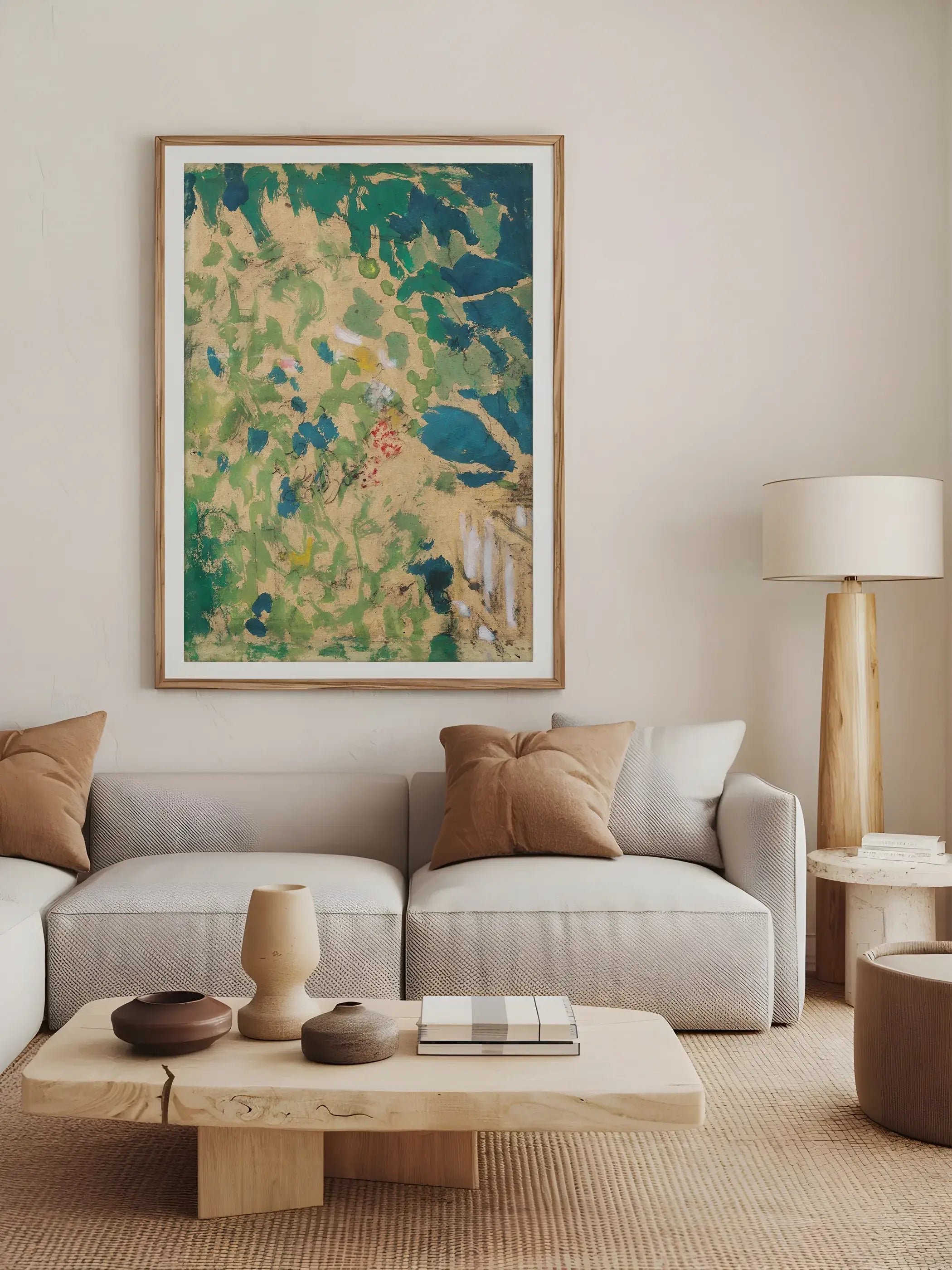 Großformatiges Wandbild mit abstrakter Landschaft hängt gerahmt über einem beigefarbenen Sofa in einem hellen, naturnahen Wohnzimmer mit Holzmöbeln. Der Kunstdruck setzt einen lebendigen Farbakzent in ruhiger Wohnatmosphäre.