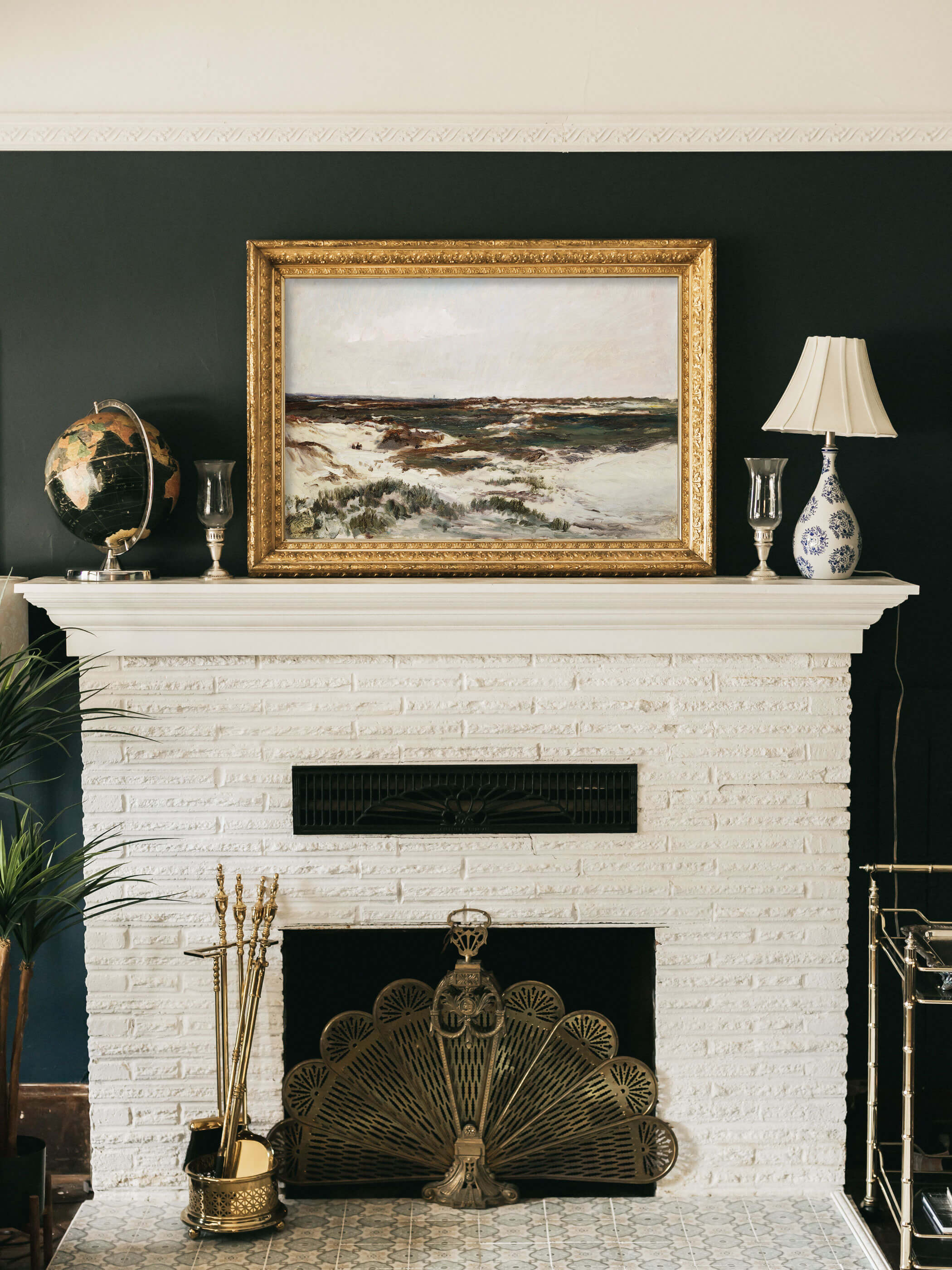 Kunstdruck der Dünen von Camiers mit goldenem Rahmen, aufgehängt über einem weißen Kamin in einem eleganten Wohnzimmer mit dunkelgrünen Wänden.