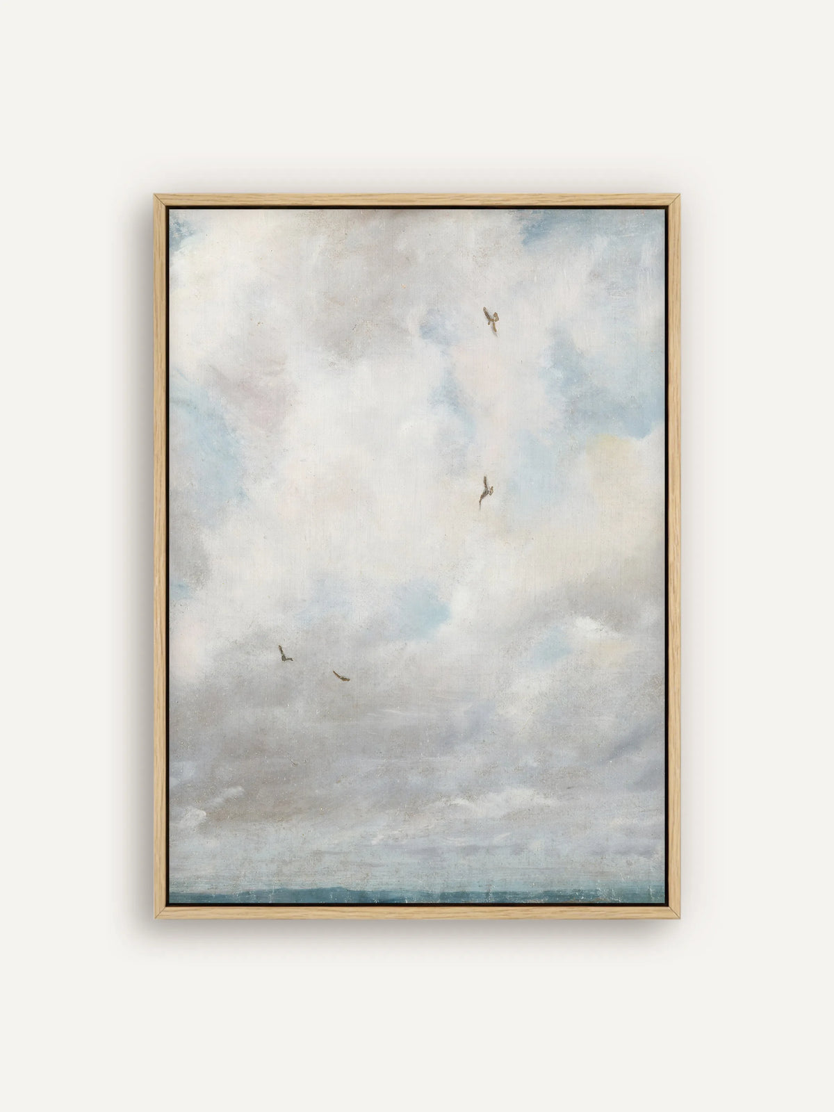 Vintage Leinwandbild im Hochformat im naturfarbenen Schattenfugenrahmen. Weiche Wolken in Weiß, Grau und Hellblau füllen die Fläche, einige kleine Vögel kreisen darin, unten liegt ein schmaler blaugrüner Horizont. #Rahmen_Natur