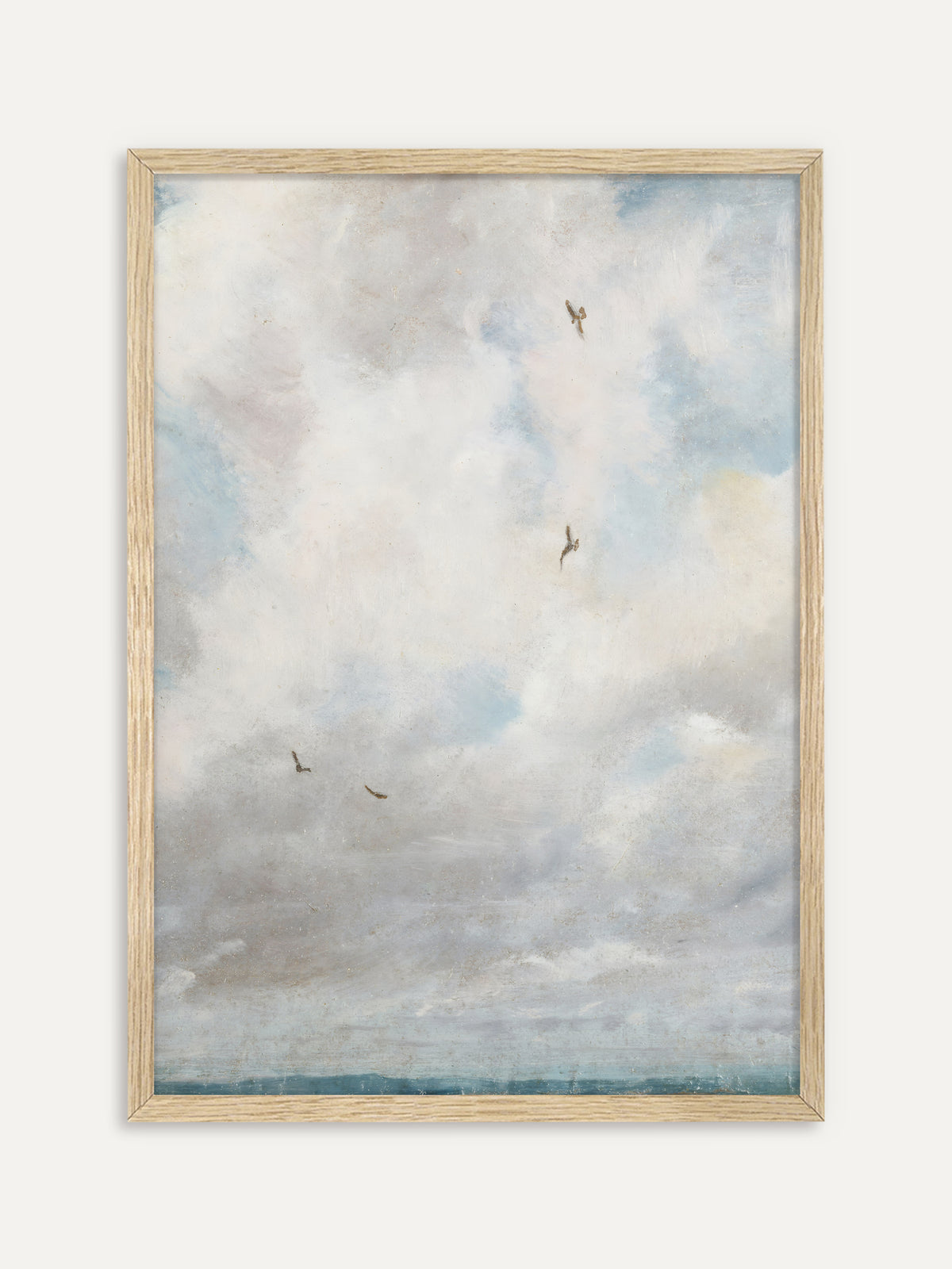 Kunstdruck, der einen weiten, hellen Wolkenhimmel in Weiß, Grau und Hellblau mit vier fliegenden Vögeln über einem schmalen blauen Horizont zeigt. Im Rahmen aus hellem Holz wirkt der Wolkenhimmel leicht und passt in ruhige Japandi-Räume. #Rahmen_Helles Holz
