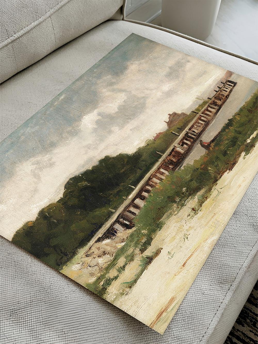 Kunstdruck einer impressionistischen Küstenlandschaft, locker auf einer hellen Couch liegend. Die strukturierte Oberfläche und die sanften Farbverläufe des Gemäldes heben den authentischen Vintage-Charakter hervor.