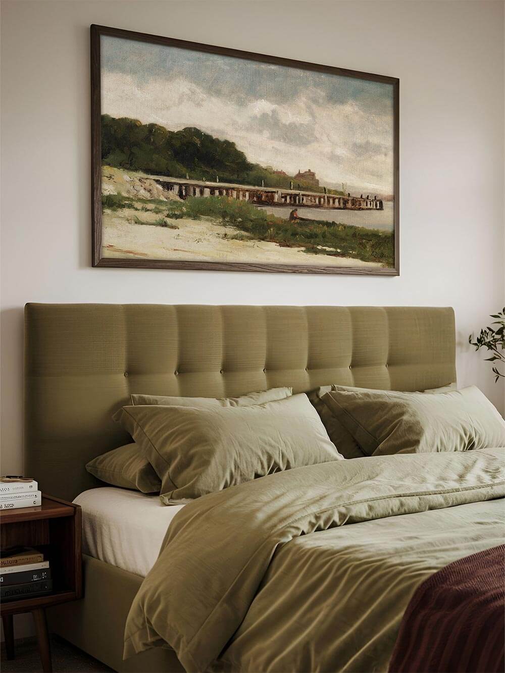 Gerahmter Kunstdruck mit impressionistischer Küstenlandschaft als Blickfang über einem Bett mit grüner Bettwäsche. Die sanften Farben und die beruhigende Szenerie fügen sich harmonisch in das Schlafzimmer-Ambiente ein.