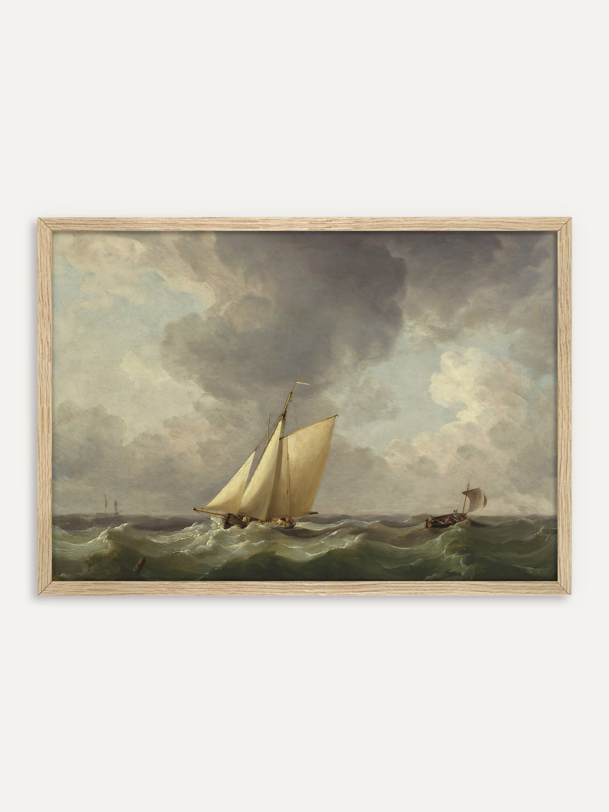 Kunstdruck, der ein Segelboot mit cremeweißen Segeln und ein kleineres Boot auf grünen, schäumenden Wellen unter einem dramatischen grauen Wolkenhimmel zeigt. Im Rahmen aus hellem Holz wirkt die maritime Vintage-Szene frisch und hell. #Rahmen_Helles Holz