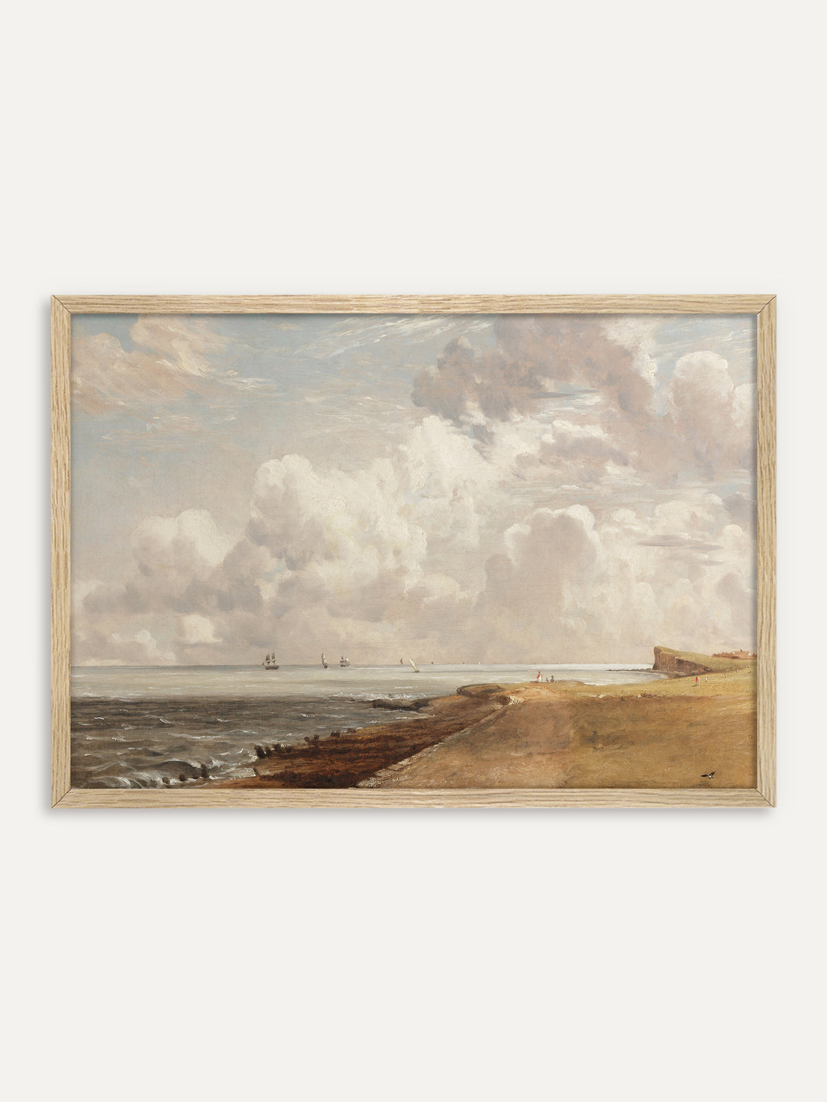 Kunstdruck, der eine sandige Küste mit Wellenbrechern und einer Steilküste zeigt, auf der grauen See fahren Segelschiffe unter hohen weißen Wolkentürmen. Im Rahmen aus hellem Holz wirkt die Vintage-Meereslandschaft hell und luftig. #Rahmen_Helles Holz