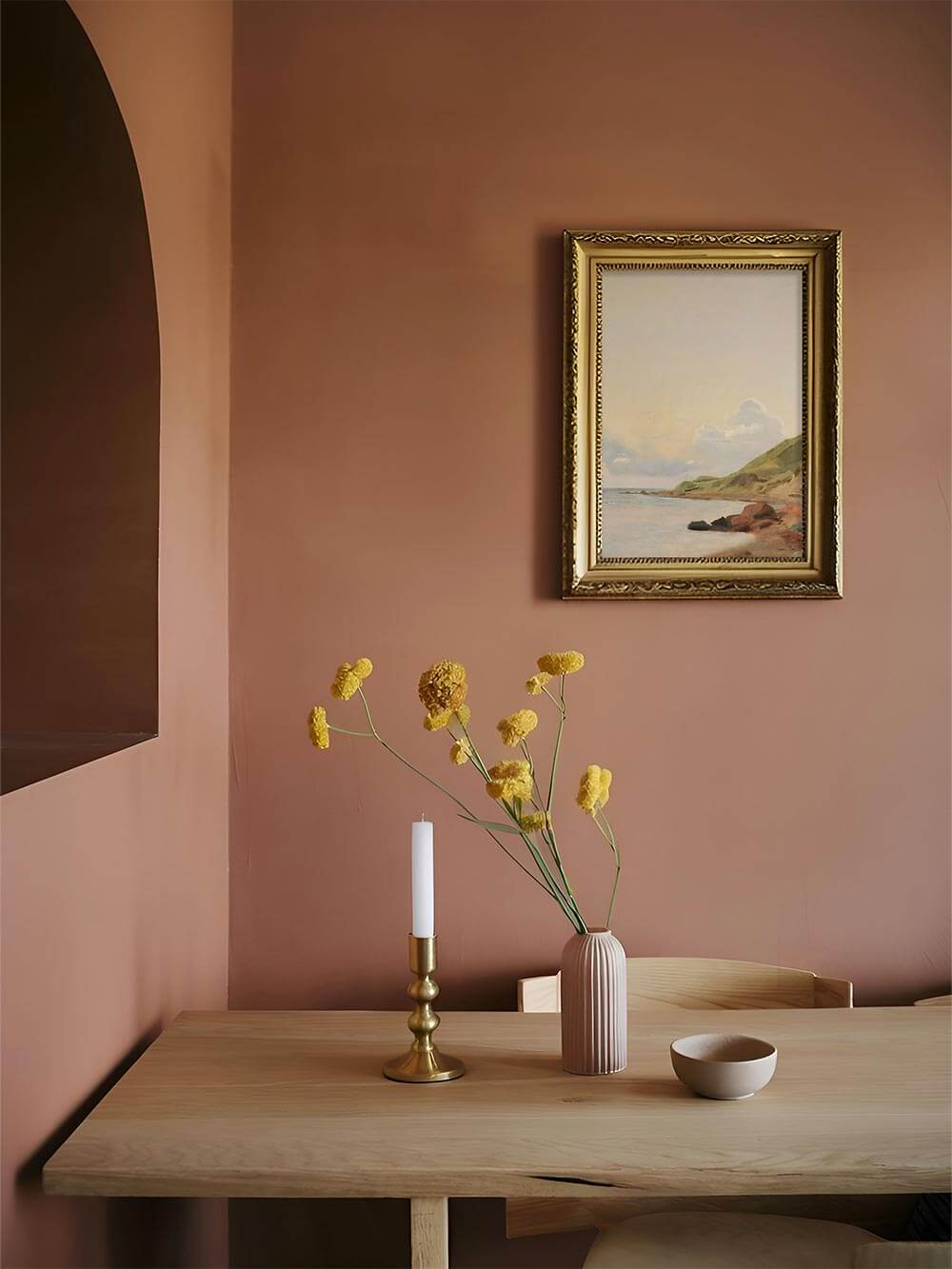 Vintage-Küstenlandschaft als gerahmter Kunstdruck in einem warmen, minimalistischen Esszimmer – pastellige Naturtöne für eine beruhigende Atmosphäre.