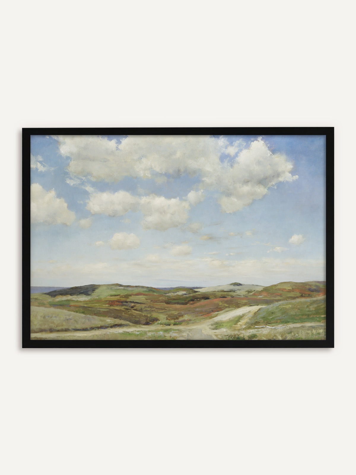 Gerahmtes Poster, das eine Dünenlandschaft mit weißen Sommerwolken über sandigen Hügeln zeigt, bewachsen mit Heide in Grün und Rostrot, durch die ein heller Weg zum Meer führt. Mit schwarzem Rahmen bekommt der helle Himmel klare Kanten, und das Bild wirkt modern. #Rahmen_Schwarz