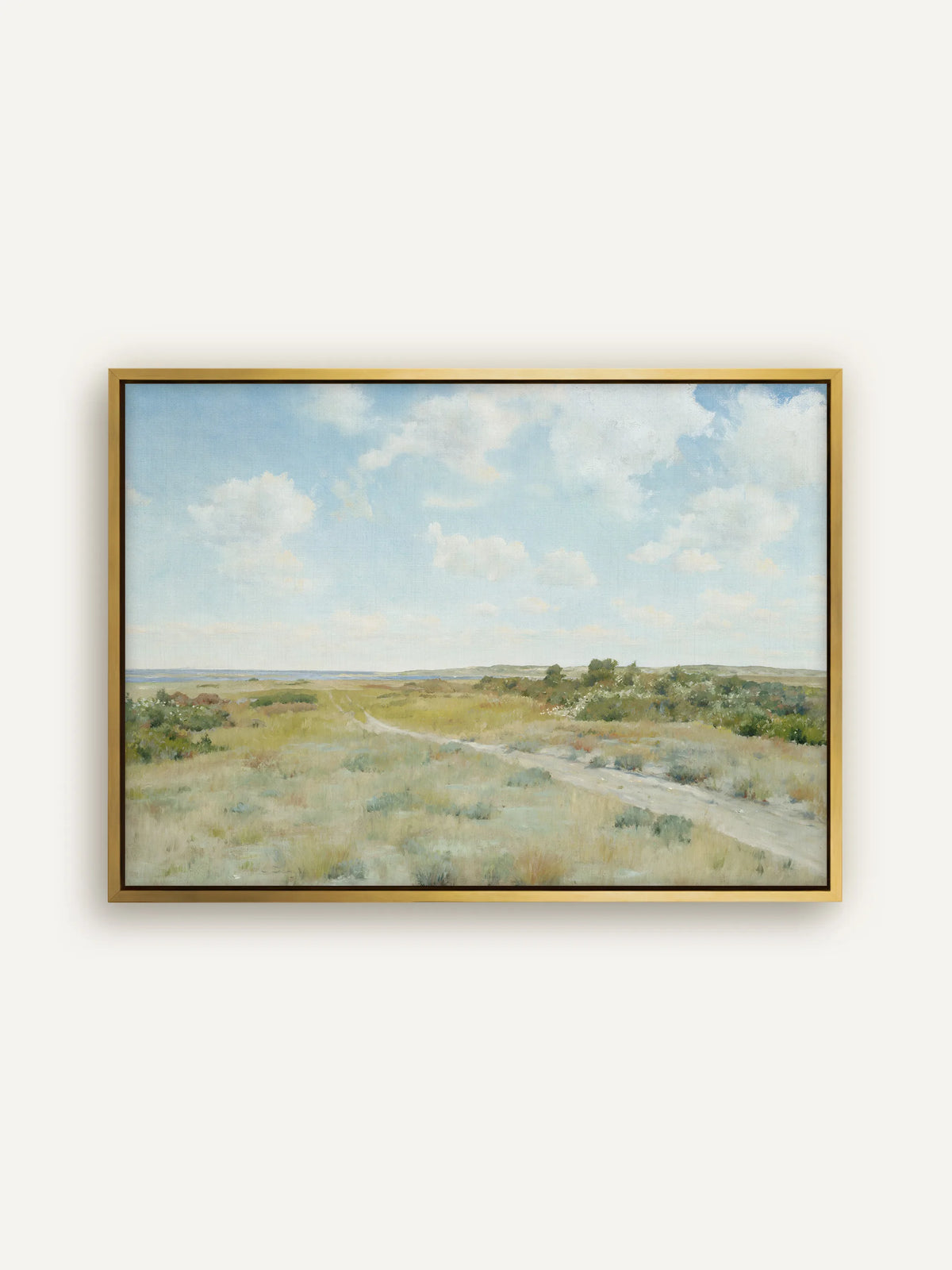 Landschaft am Meer als Leinwandbild im goldenen Schattenfugenrahmen. Das Gold nimmt die gelbgrünen und ockerfarbenen Töne des Grases auf, über dem lockere Wolken stehen. #Rahmen_Gold