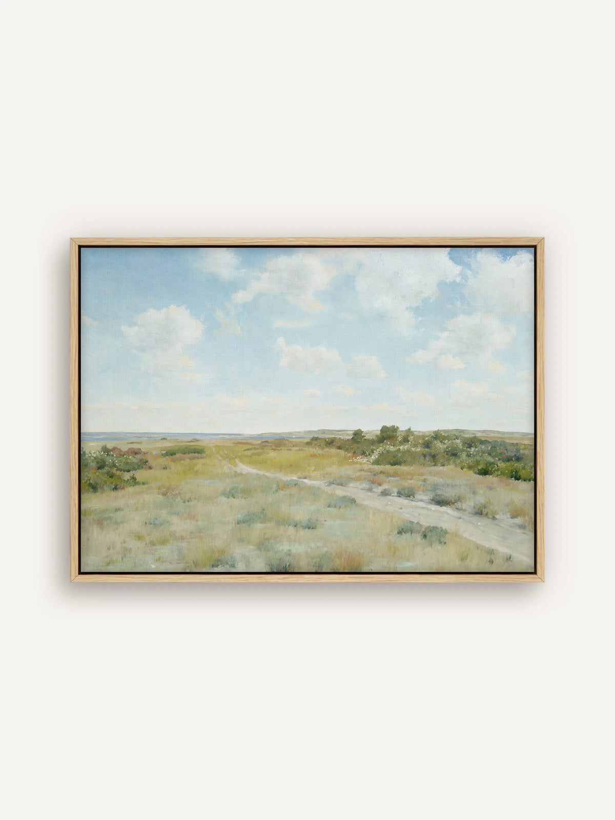 Vintage Leinwandbild im Querformat im naturfarbenen Schattenfugenrahmen. Ein sandiger Weg führt durch eine weite Heide mit Gras und Sträuchern in Salbeigrün und Ocker, am Horizont liegt blaues Wasser. #Rahmen_Natur