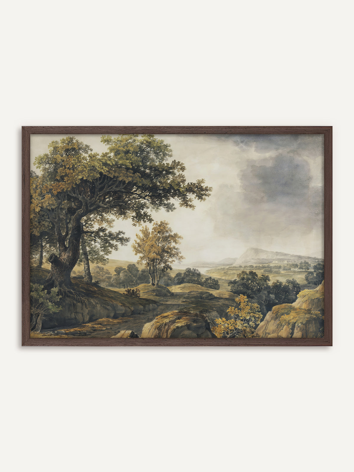 Poster, das eine weite Landschaft mit einer alten Eiche am Hang, einem Felsweg und Bäumen in Grün und Ocker unter grauen Regenwolken zeigt, in der Ferne ein Berg über einem See. Der Rahmen aus dunklem Holz unterstreicht die moody Stimmung des aufziehenden Regens. #Rahmen_Dunkles Holz