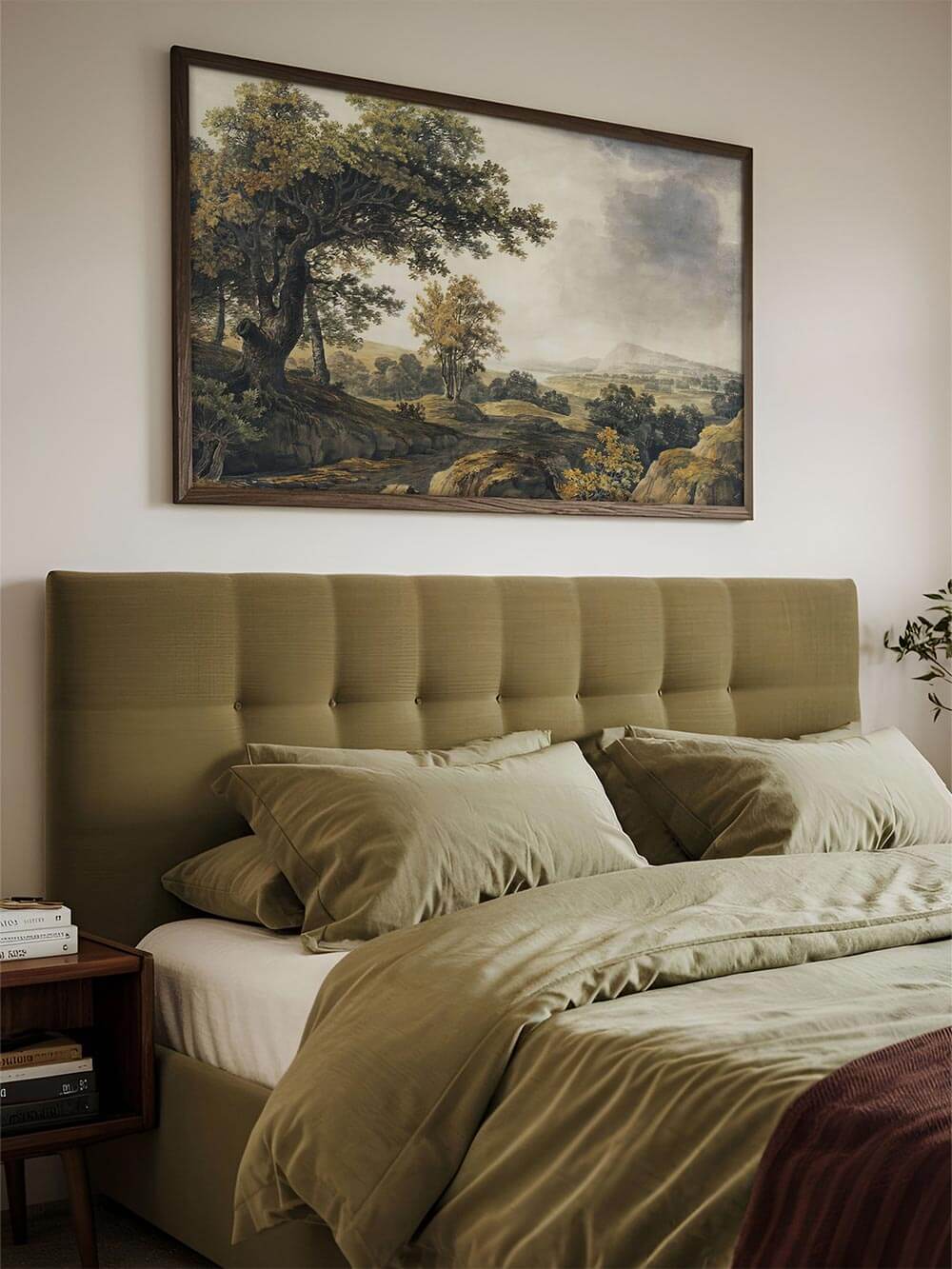 Gerahmter Landschafts-Kunstdruck hängt über einem olivgrünen Bett. Das Vintage Wandbild bringt eine ruhige, naturverbundene Atmosphäre ins Schlafzimmer.
