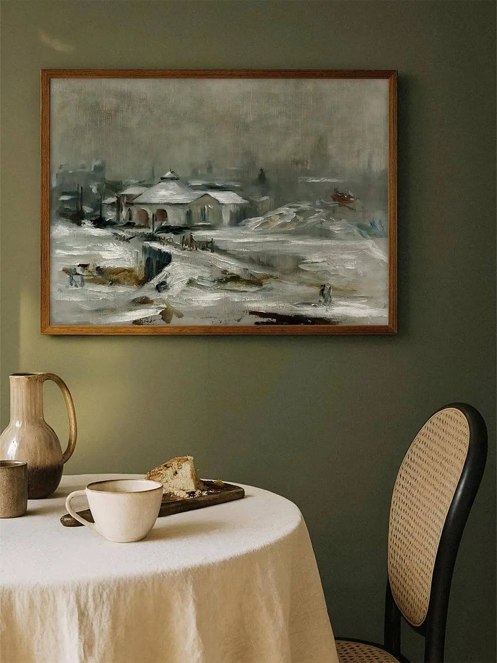 Der Winterlandschaft Kunstdruck hängt gerahmt an einer grünen Wand über einem gedeckten Tisch. Das ruhige Motiv bringt nostalgische Eleganz in den Raum.
