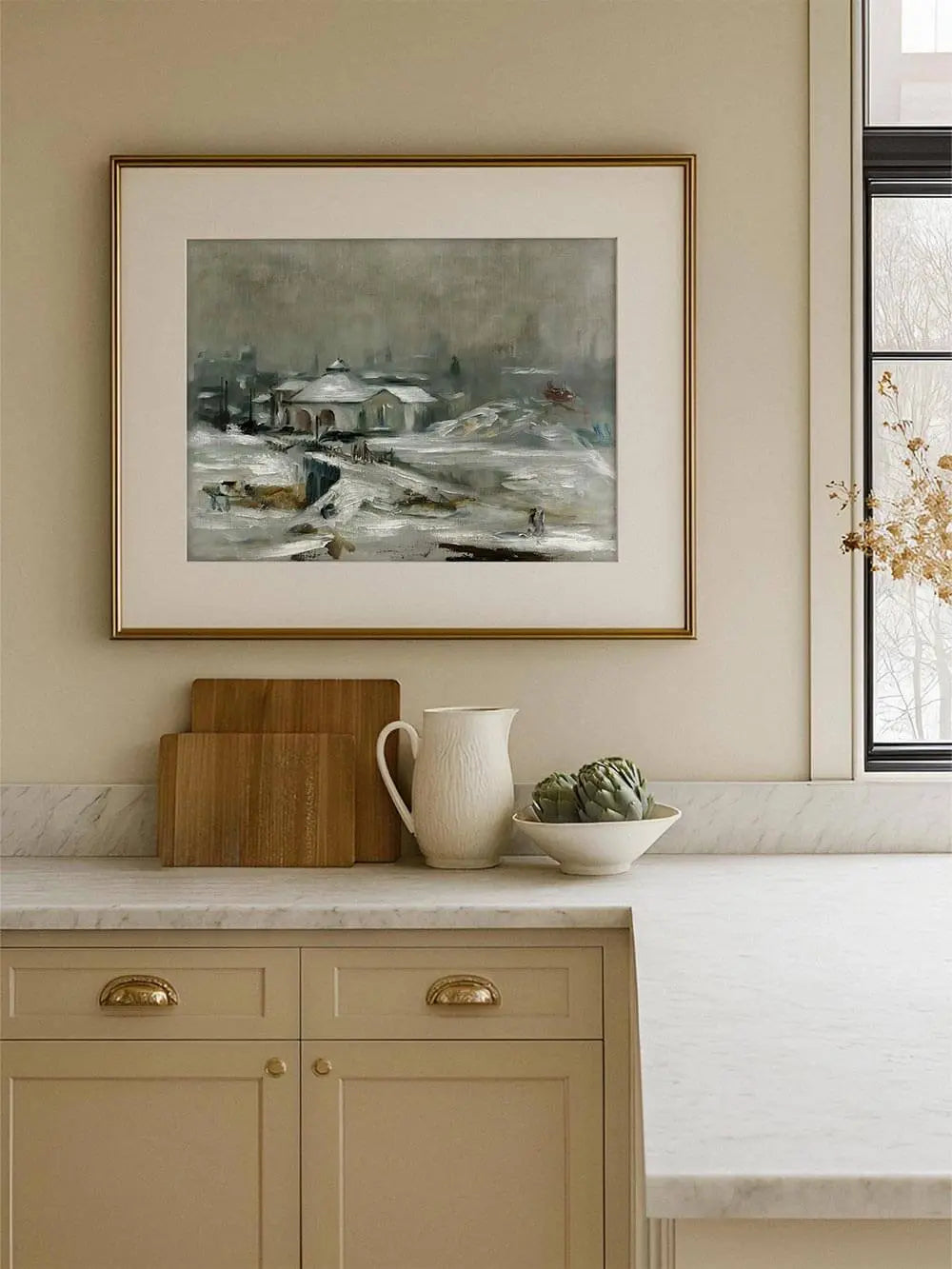 Winterlandschaft Kunstdruck in hellem Rahmen hängt über einer Küchenarbeitsplatte. Die frostige Szenerie fügt sich sanft in das warme Interieur ein.