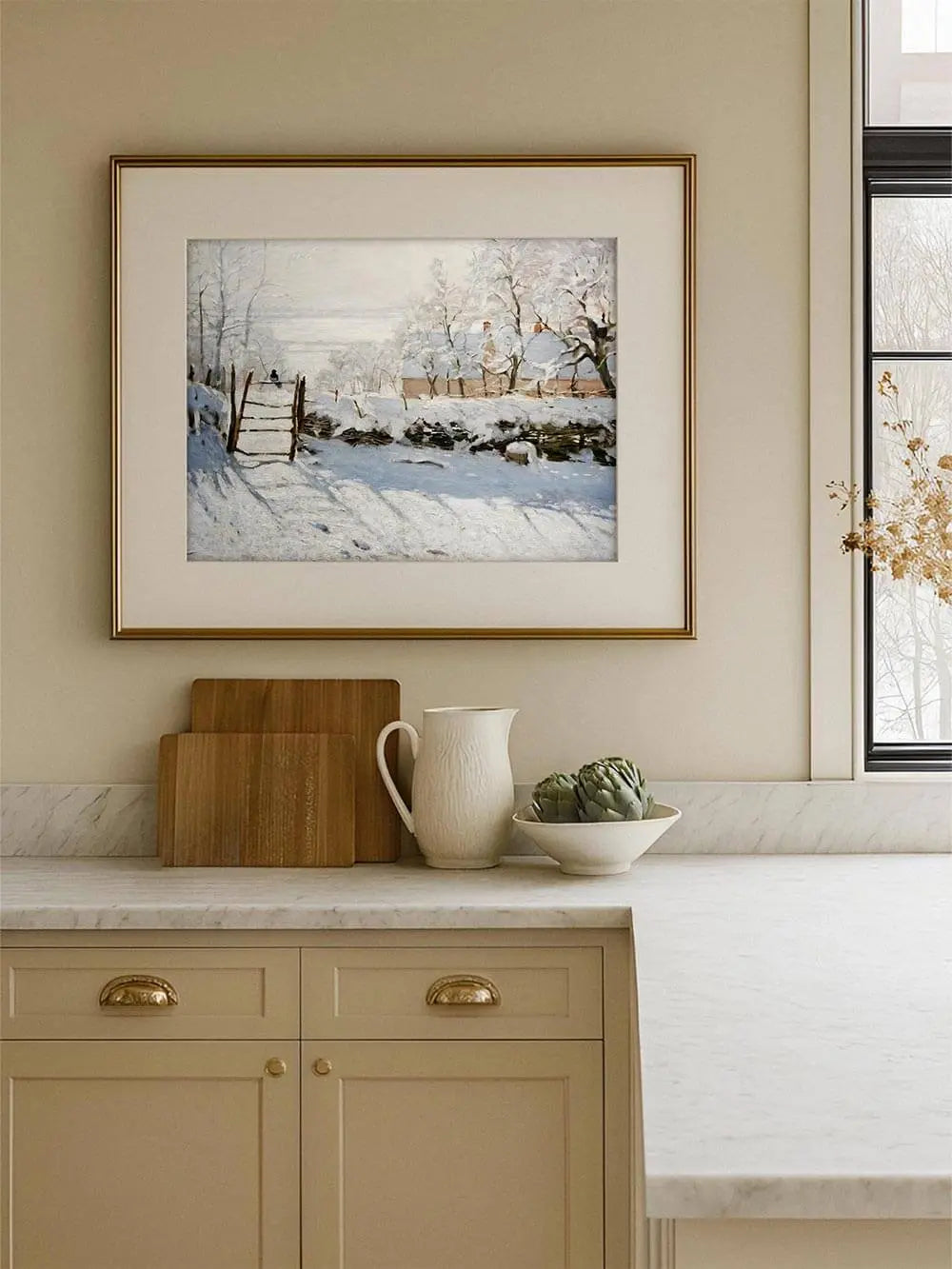 Winterlicher Monet Kunstdruck mit verschneiter Landschaft hängt gerahmt in einer hellen Küche, die Illustration fügt sich harmonisch in ein ruhiges Wohnambiente ein.