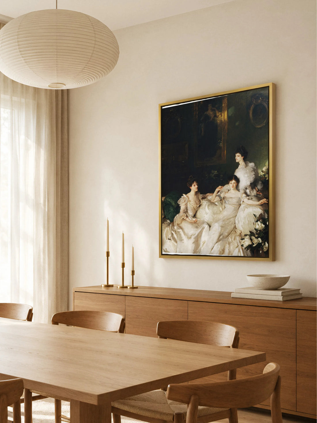 Leinwandbild mit drei Frauen in Weiß im goldenen Rahmen über einem Sideboard aus Eiche mit Kerzenleuchtern aus Messing im hellen Esszimmer