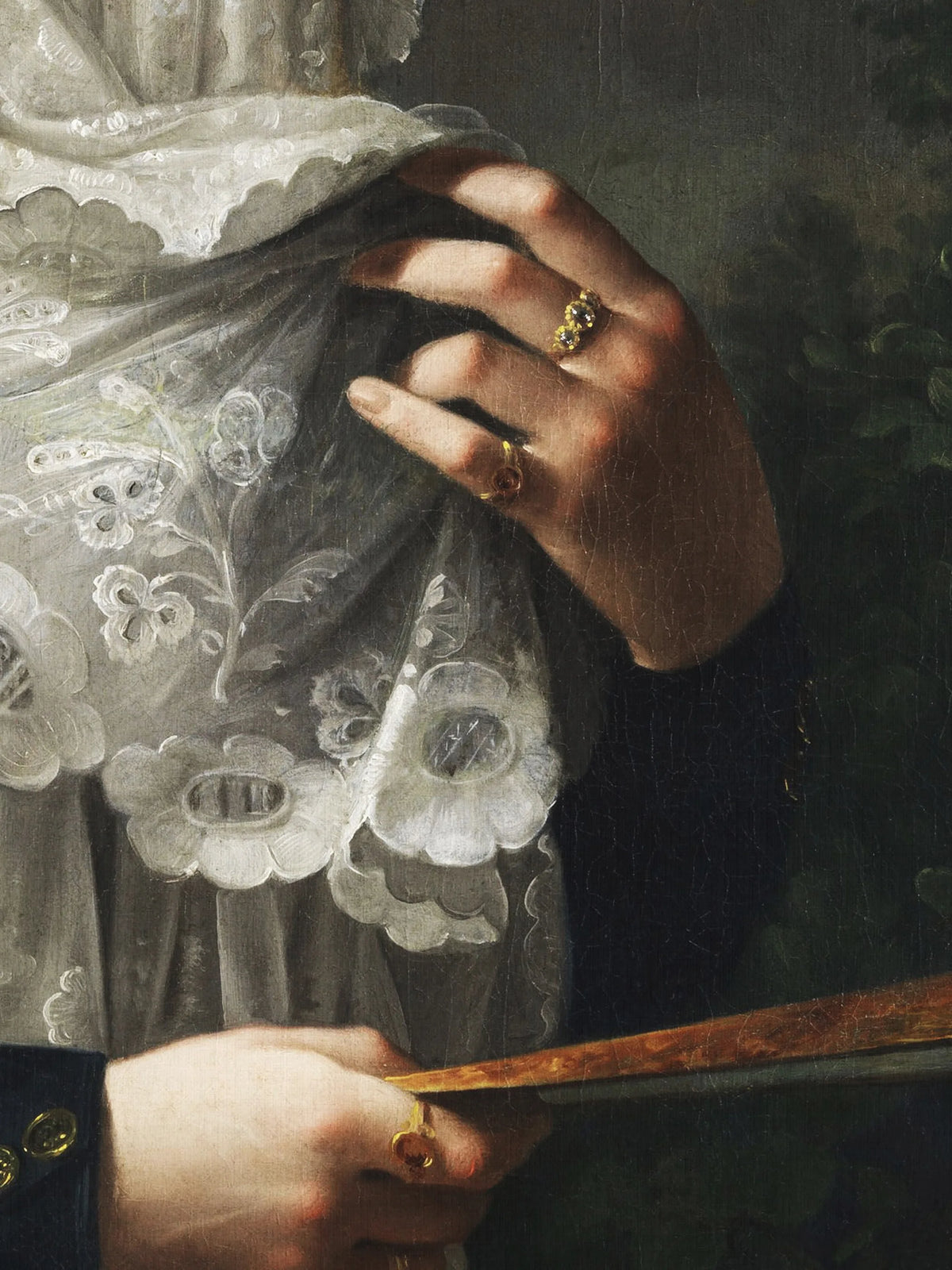 Detail des Leinwandbilds nach López Portaña: Finger mit goldenen Ringen greifen in weiße Spitze mit Blütenmuster, darunter der goldbraune Fächer