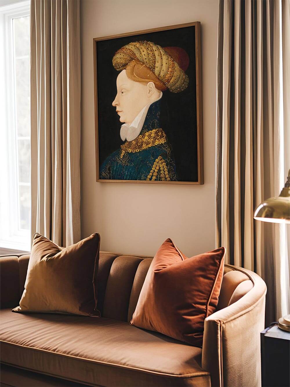 Porträt-Kunstdruck einer Frau im goldverzierten Gewand hängt über einem braunen Sofa mit Samtkissen. Zeitloses Wandbild im Renaissance-Stil, das moderne Interieurs mit kunstvoller Tiefe und kultiviertem Flair ergänzt.