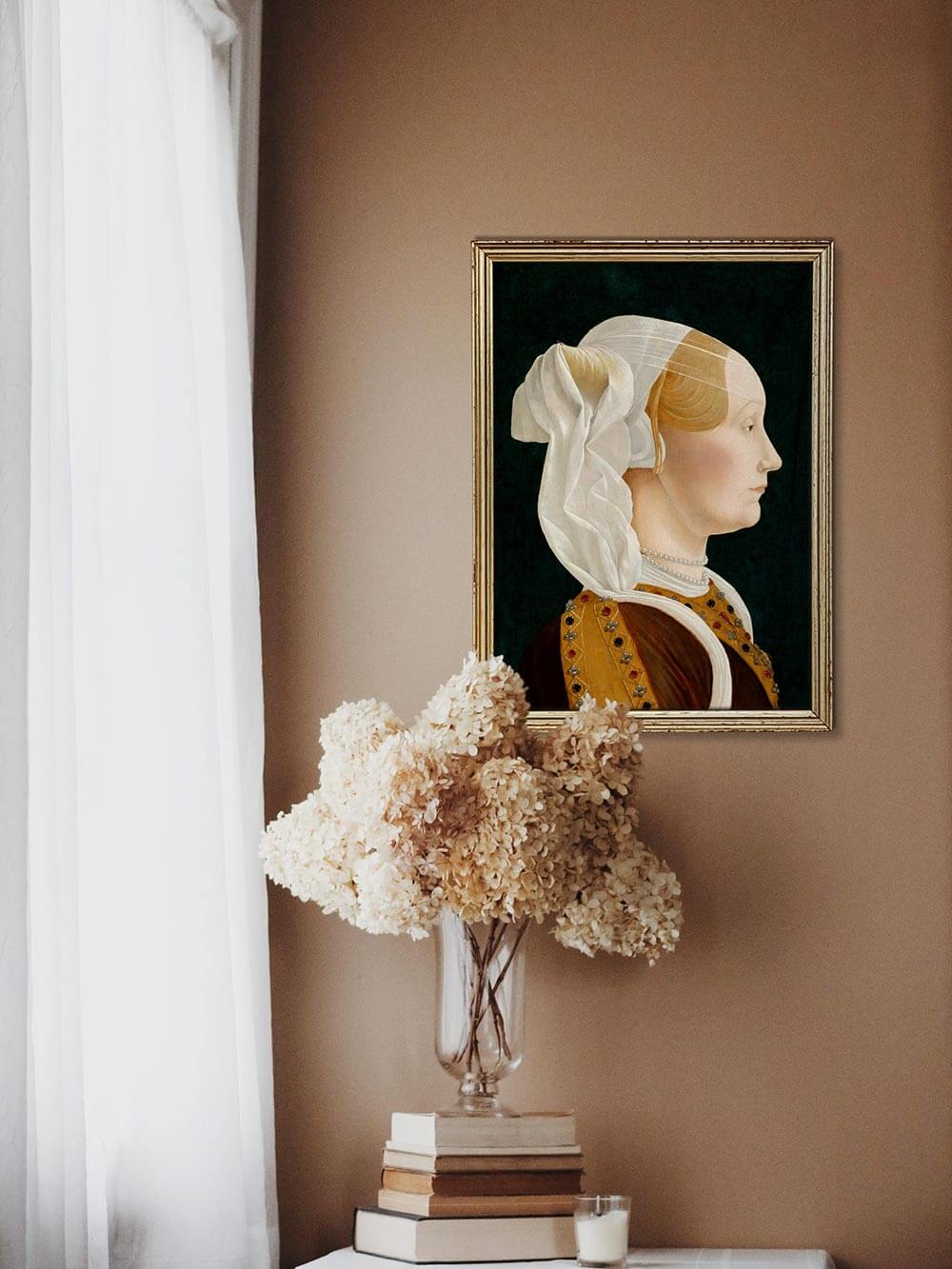 Gerahmter Kunstdruck einer Frau im Renaissance-Stil über einer Vase mit Trockenblumen und gestapelten Büchern. Warme, sanfte Lichtstimmung unterstreicht die historische Eleganz des Wandbilds.