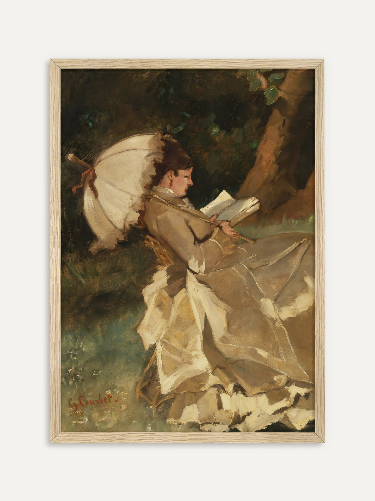 Kunstdruck, der eine Frau im beigen Rüschenkleid zeigt, die unter einem weißen Sonnenschirm mit rotem Band in einem Korbstuhl lehnt und in einem Buch liest, vor dunkelgrünem Laub und einem Baumstamm. Im Rahmen aus hellem Holz wirkt die Gartenszene leicht und sommerlich. #Rahmen_Helles Holz