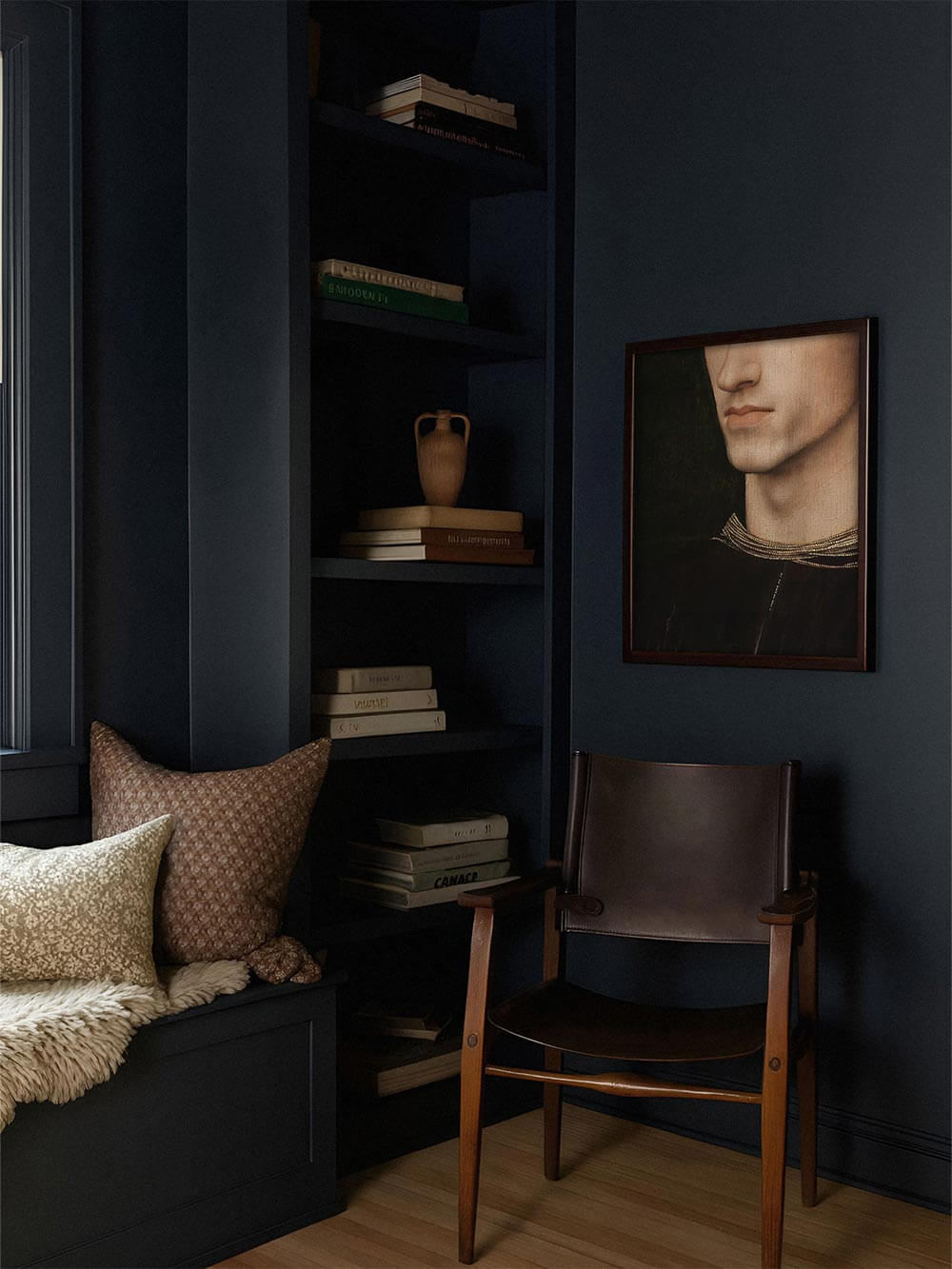 Moody Porträt-Kunstdruck in dunklen Tönen hängt in einem tiefblauen Raum über einem Ledersessel. Stilvolles Wandbild für charaktervolle Einrichtung mit Dark Academia Flair und klassischer Eleganz.